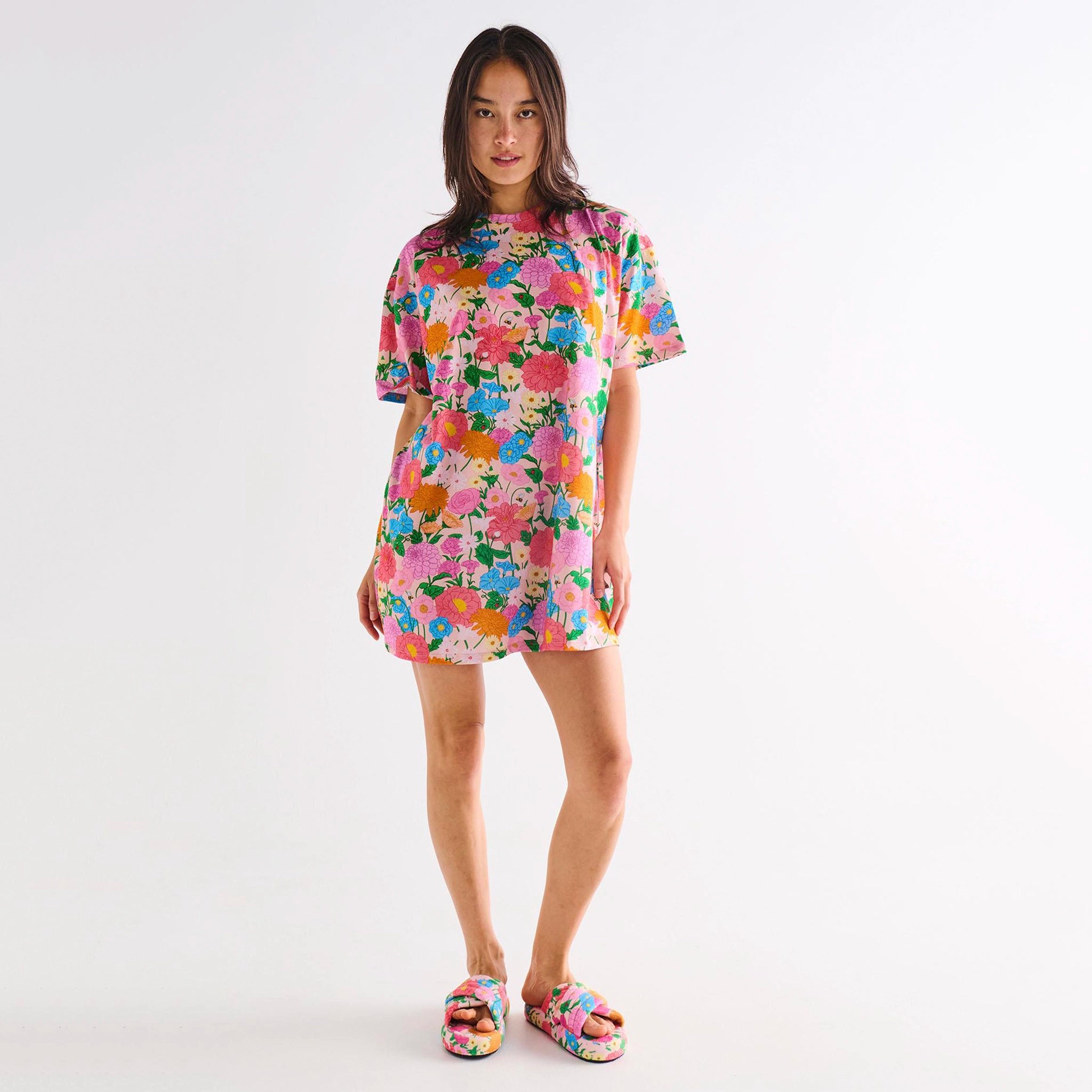 Woman wearing a colorful floral dress on a white background