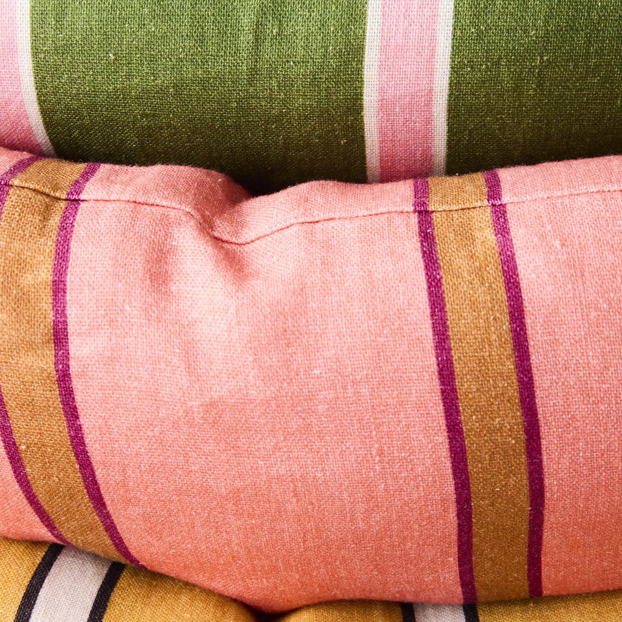 Close-up of striped fabric with pink, green, and gold colors.