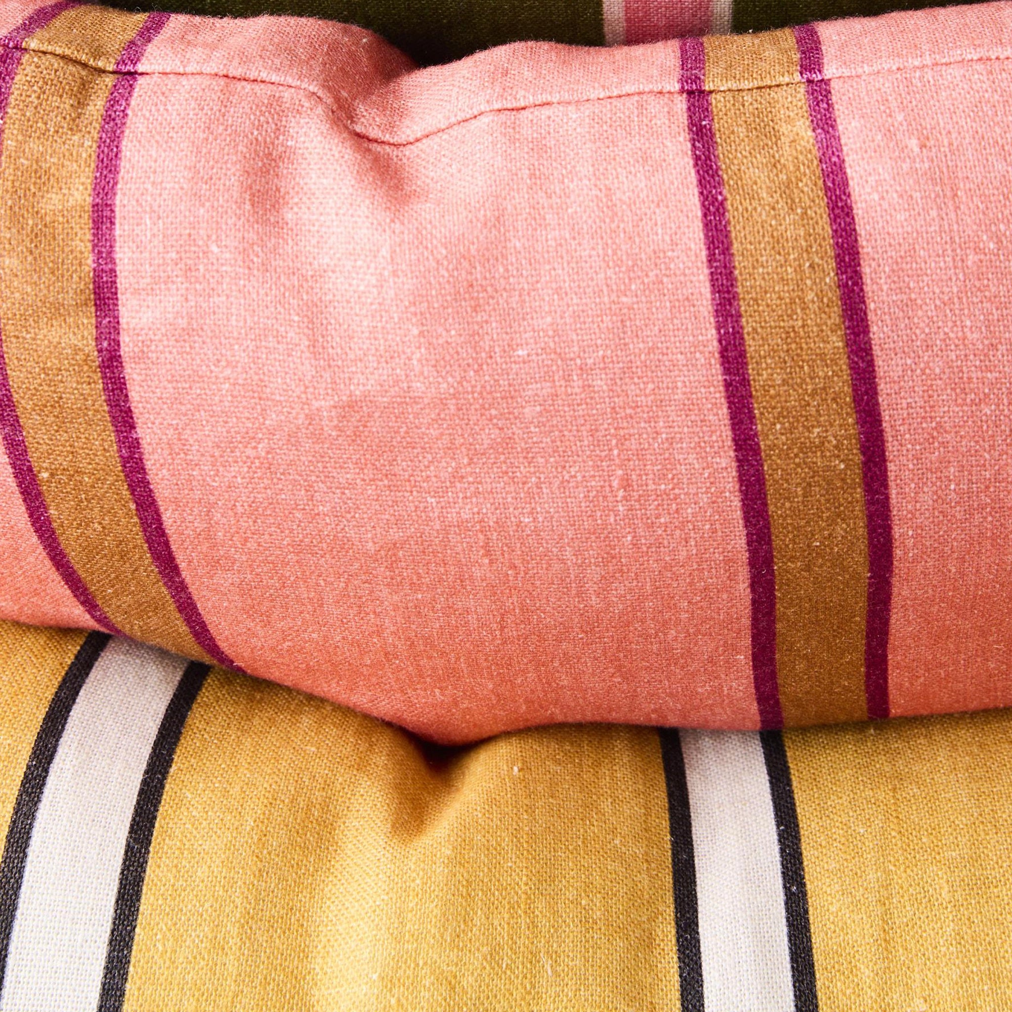 Close-up of striped fabric with pink, gold, and black colors.