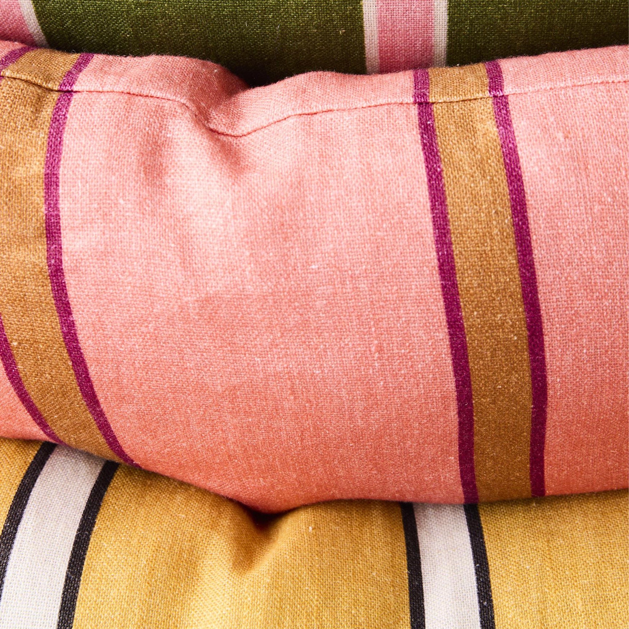 Close-up of striped fabric with pink, green, and yellow colors.