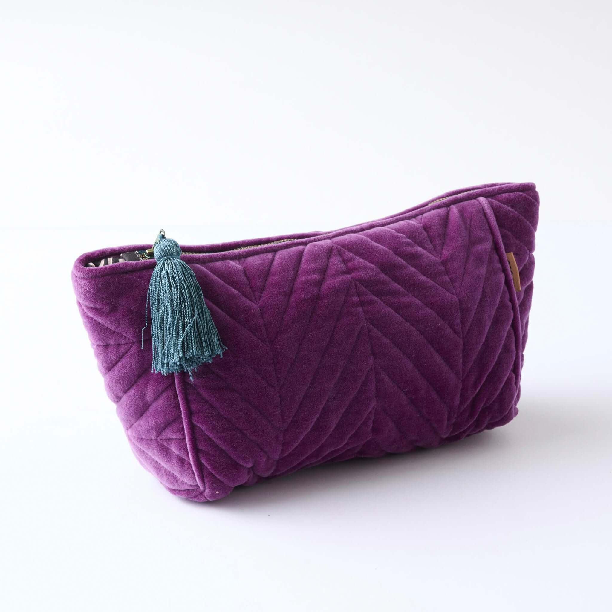 Alt Tag: Kip & Co Velvet Toiletry Bag - Wild Grape quilted grape cotton velvet cosmetic bag with blue tassel and zip closure