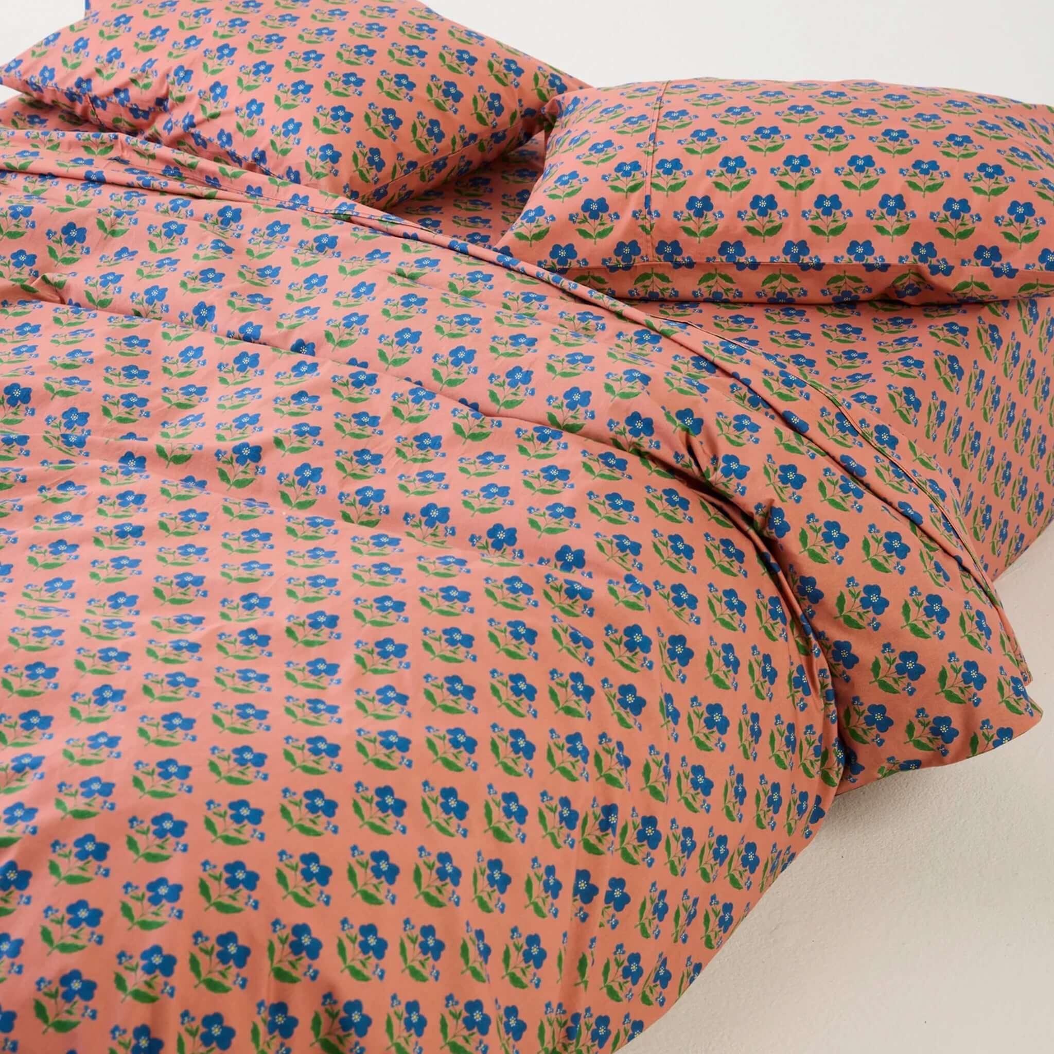 Kip & Co x Anna Spiro Organic Cotton Pillowslip Set - Indian Summer Rose on a colorful bedspread.