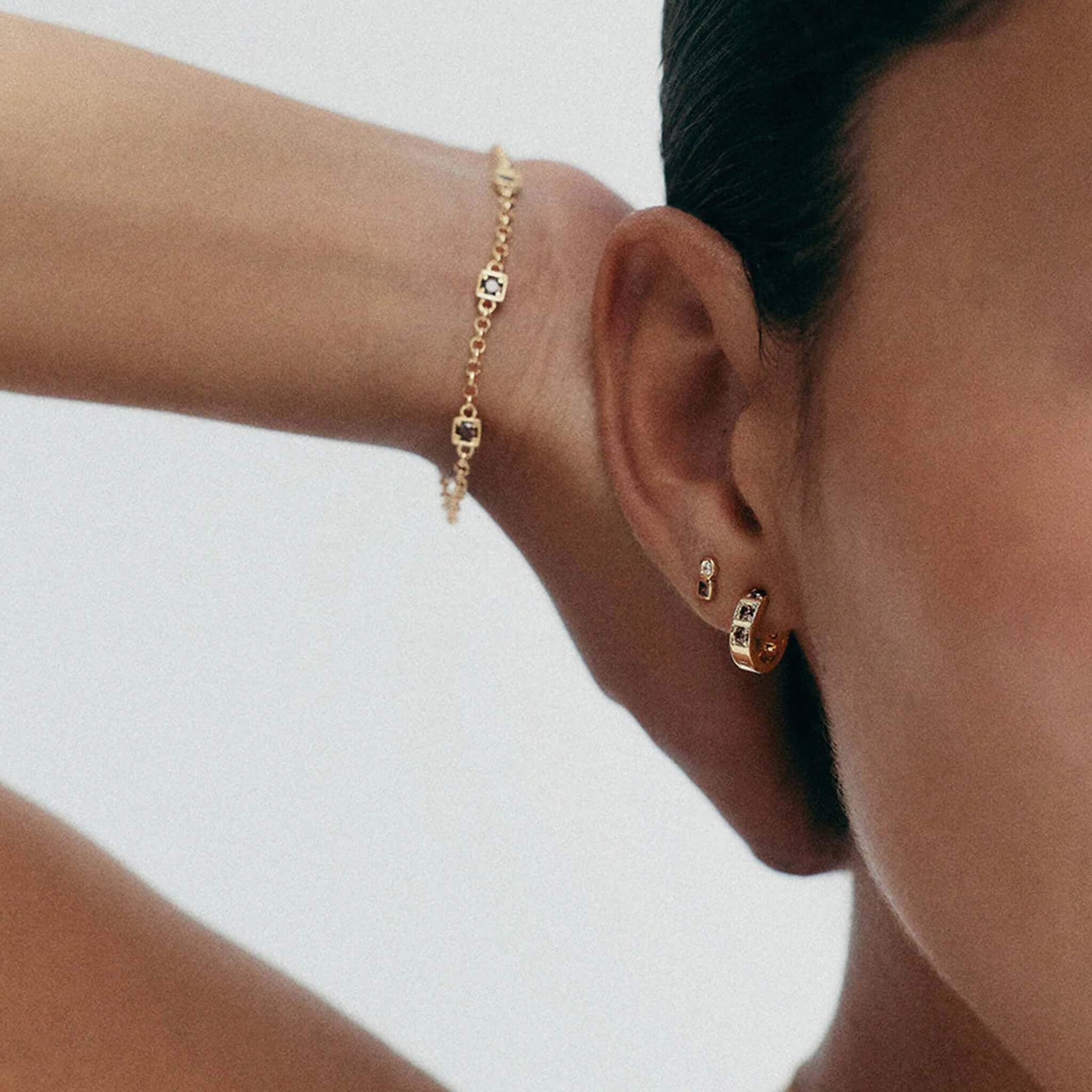 Kirstin Ash Ember Collection Renewal Huggie Earrings - Gold Plated worn by model with elegant bracelet.