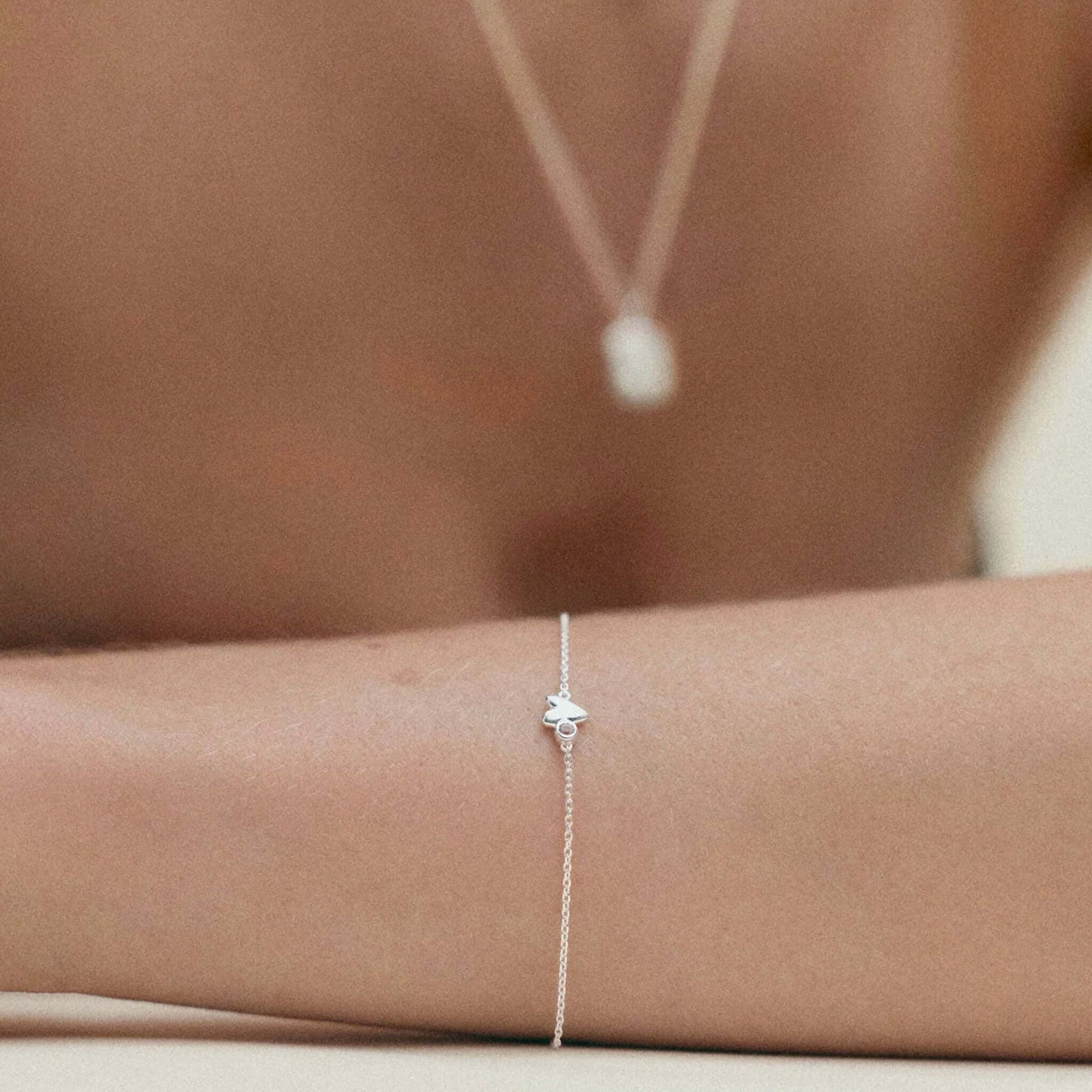 Alt Tag: Kirstin Ash Vista Collection Abode Heart Bracelet sterling silver chain bracelet with organic heart and white topaz on wrist