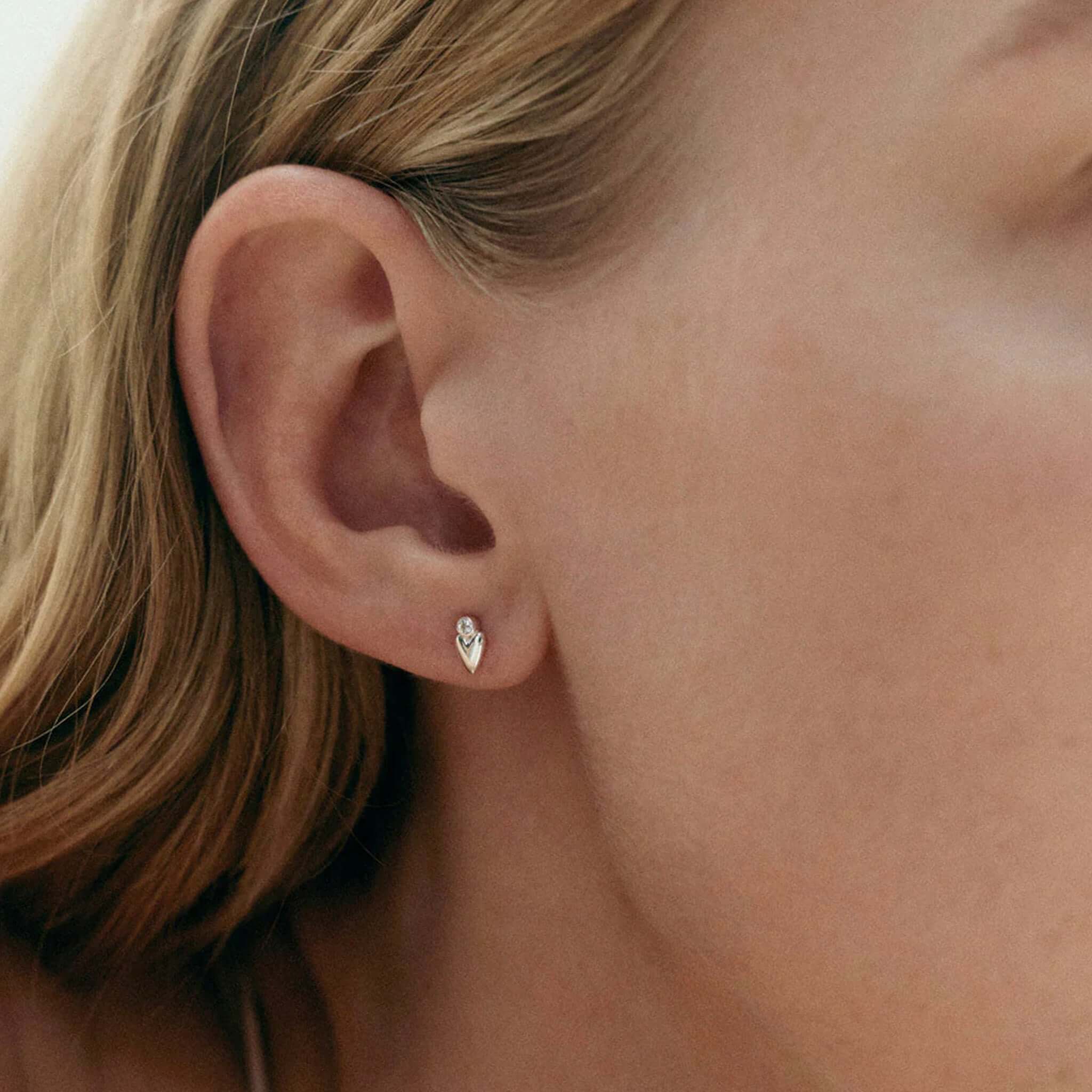 Alt Tag: Kirstin Ash Vista Collection Abode Heart Stud Earrings on ear, petite heart stud with white topaz gemstone, sterling silver