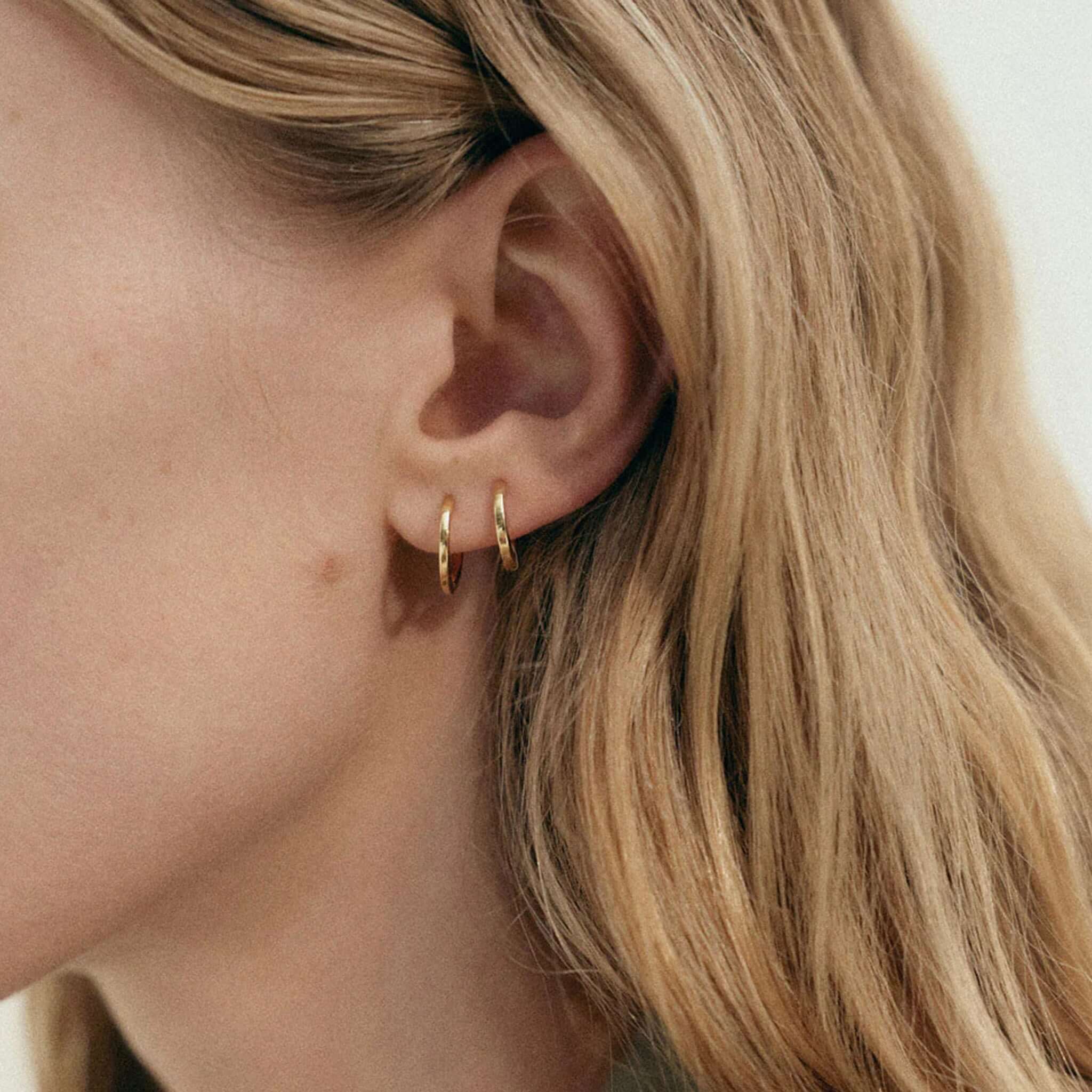 Alt Tag: Kirstin Ash Vista Collection Contour Hoop Earrings worn in ear, 18k gold-plated polished sculpted hoop earrings close-up