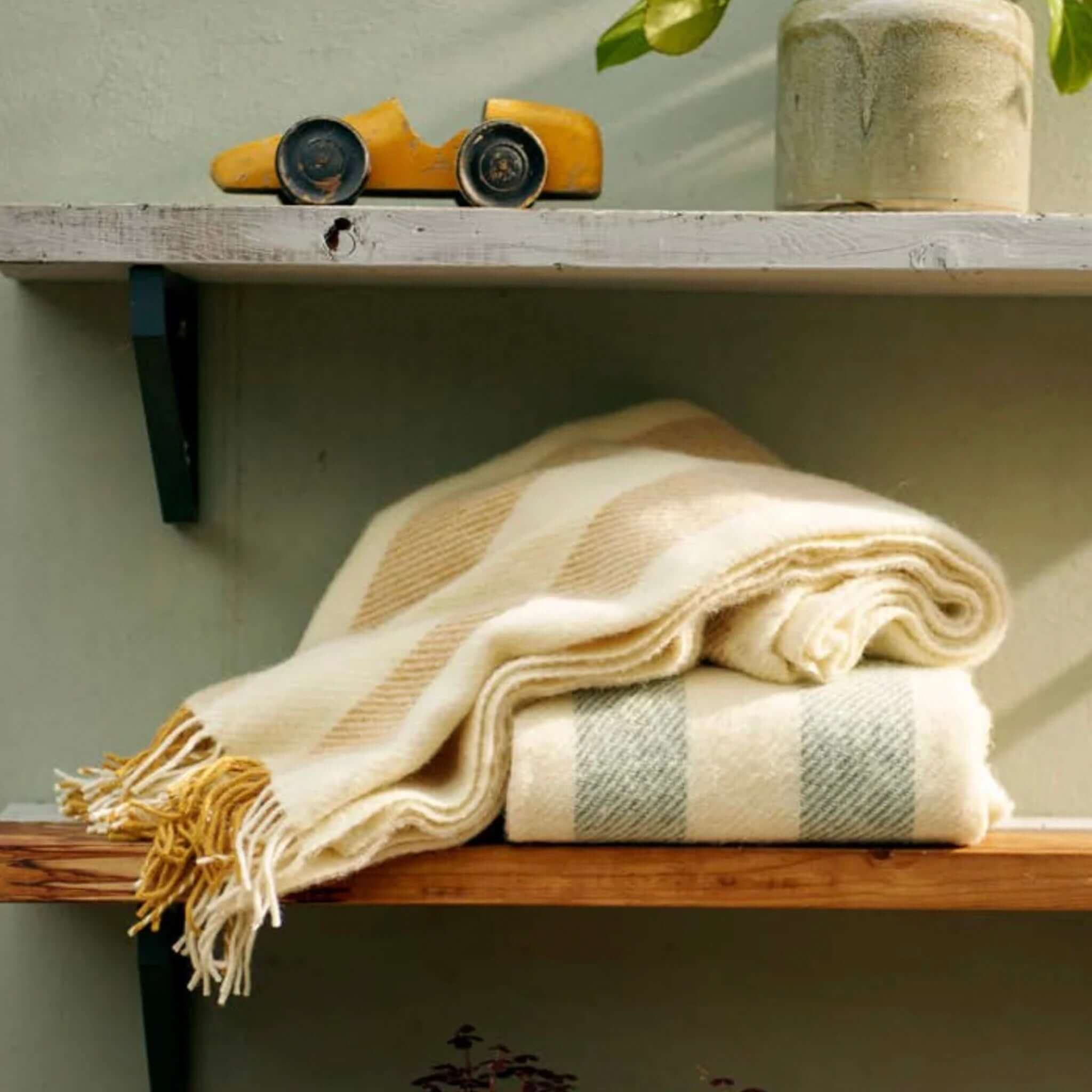 Klippan Yllefabrik Gotland Wool Vertical Stripe Throw - Heavenly Blue & White displayed on wooden shelves