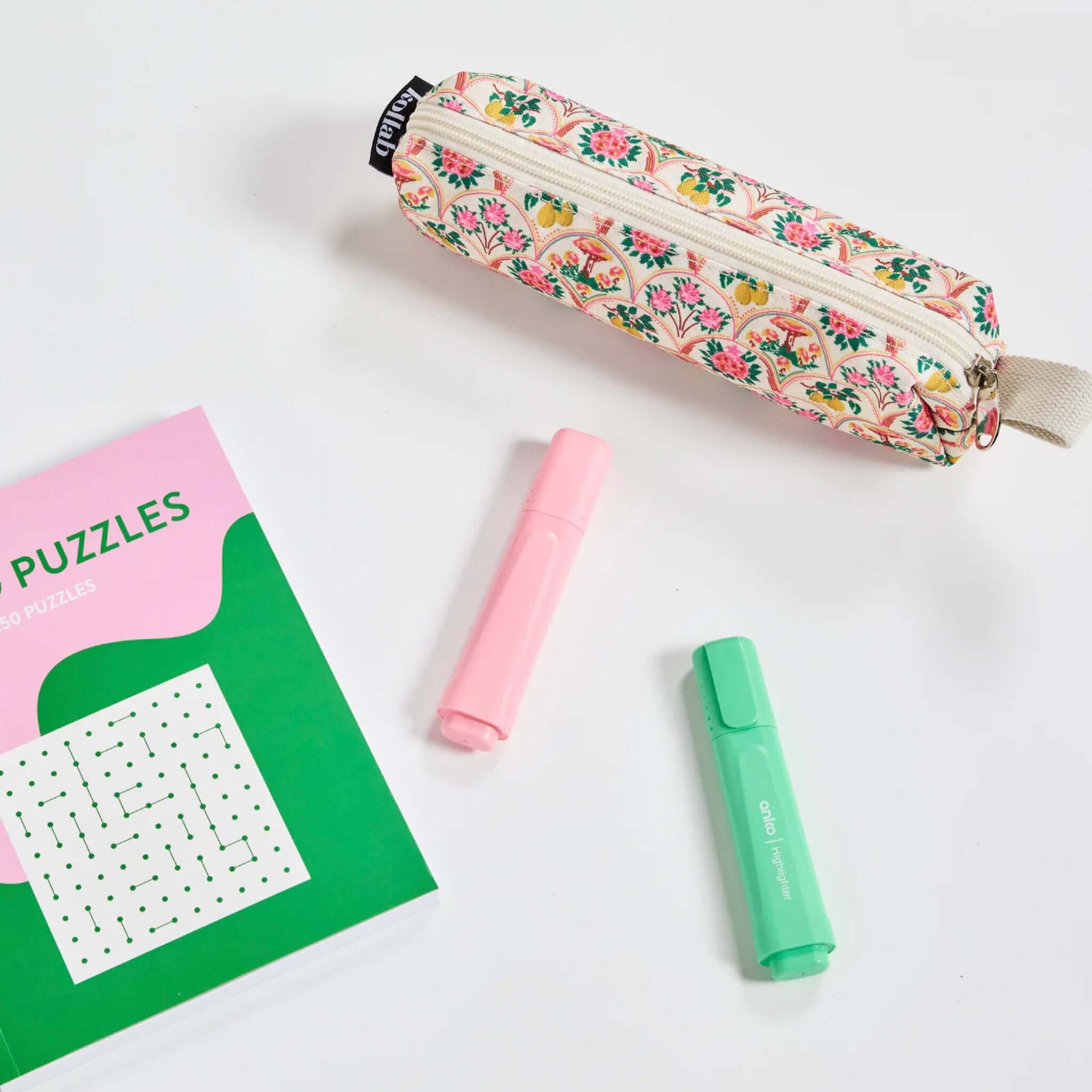 Floral-patterned pencil case with a book and two markers on a white background