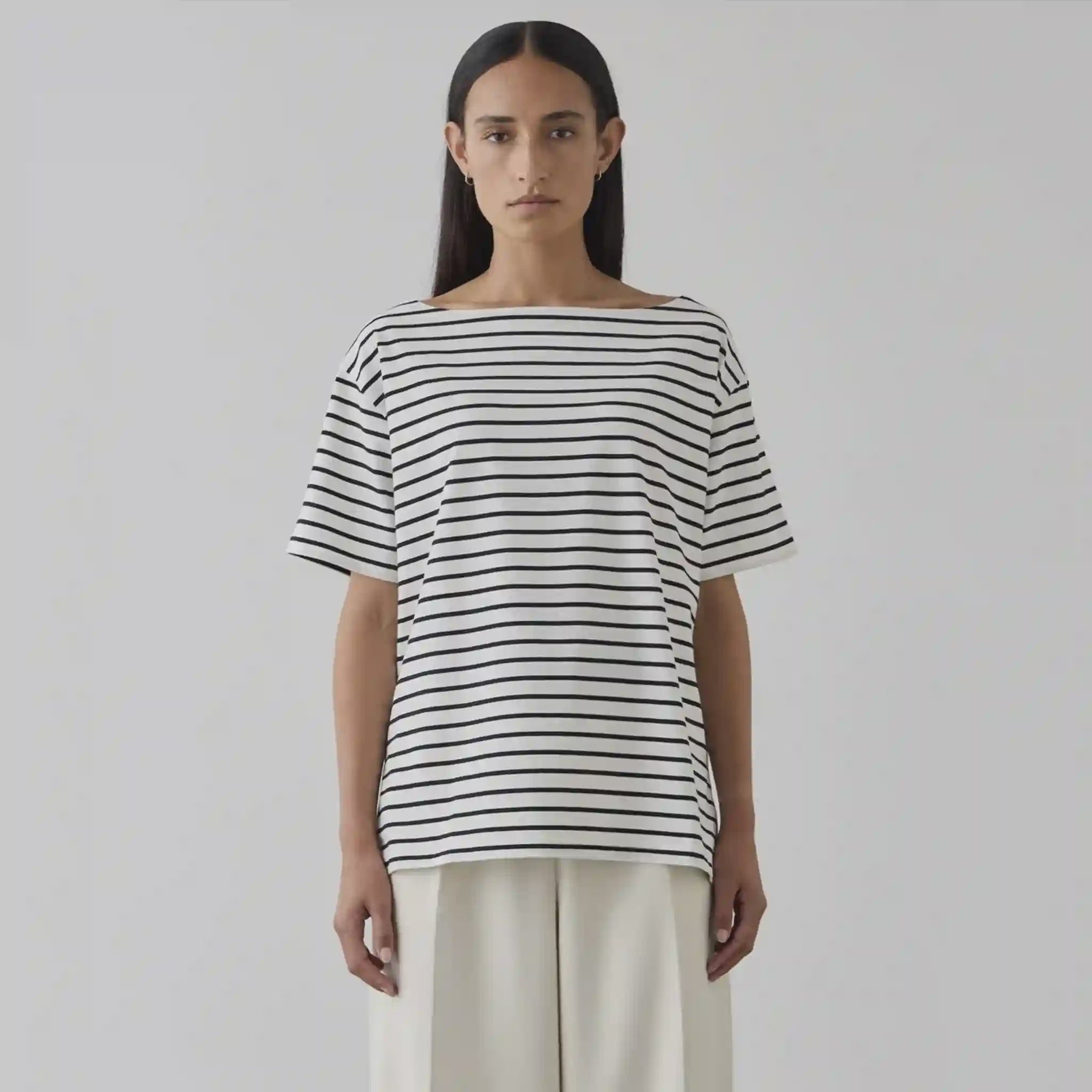 Person wearing a black and white striped shirt against a plain background