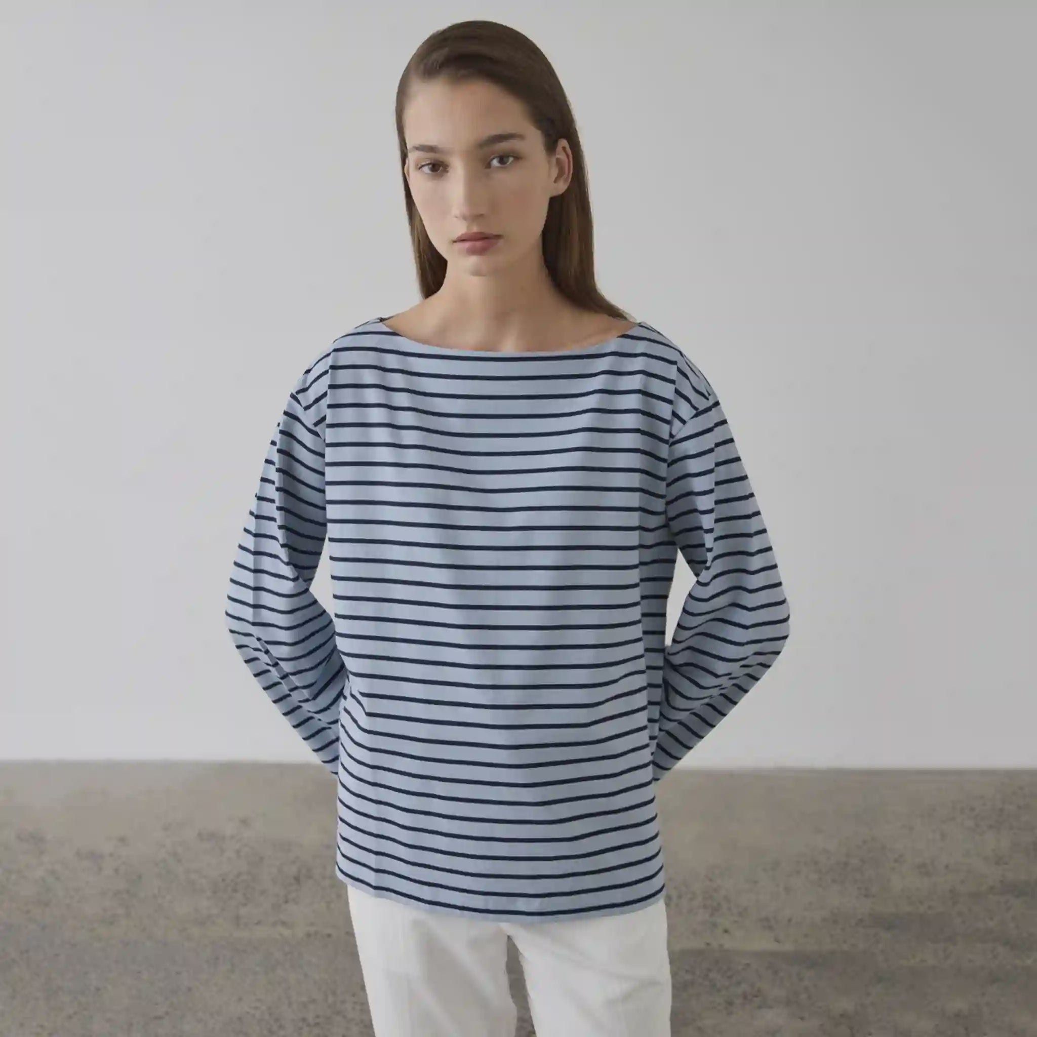 Woman wearing a blue and white striped shirt against a plain background