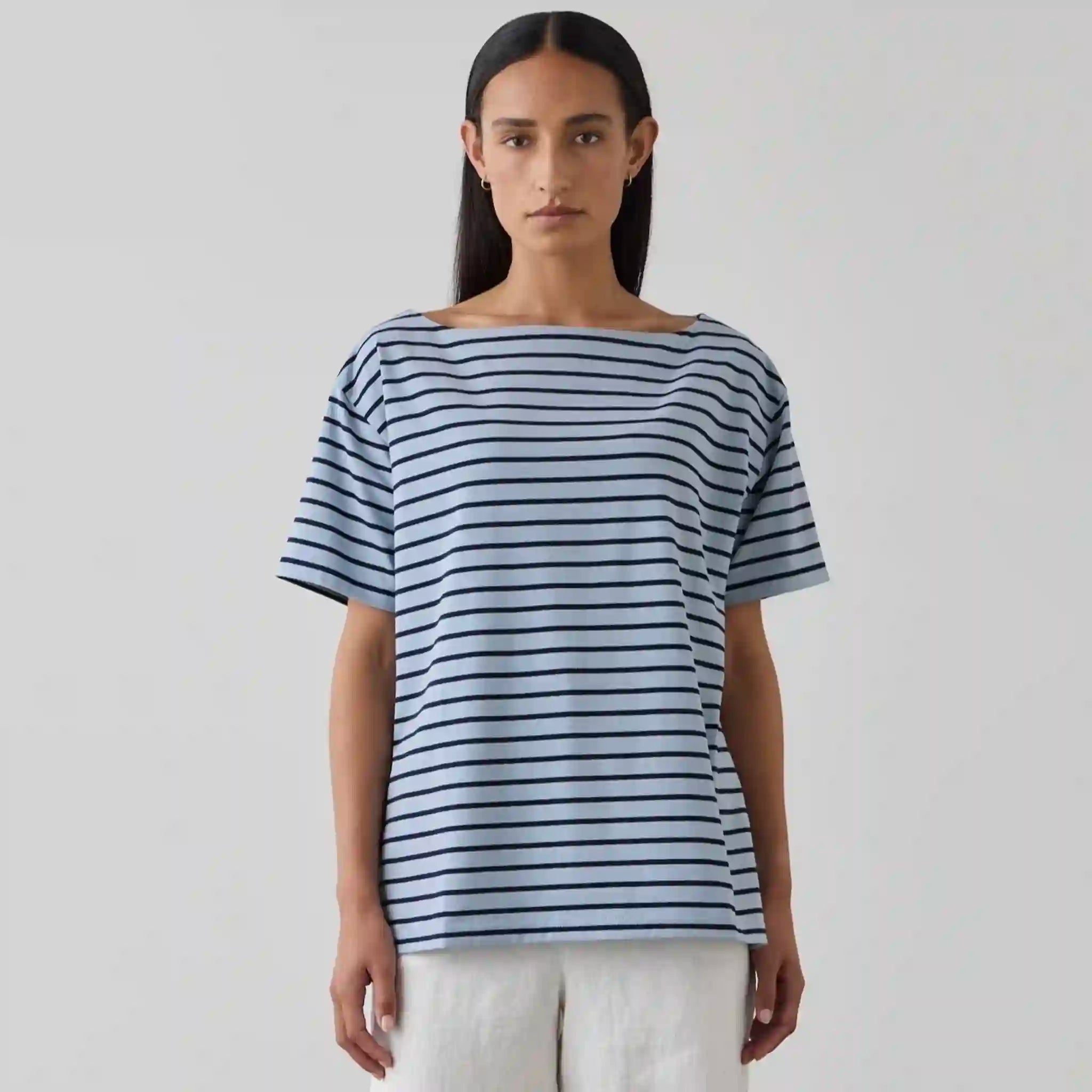 Woman wearing a blue and white striped shirt against a plain background