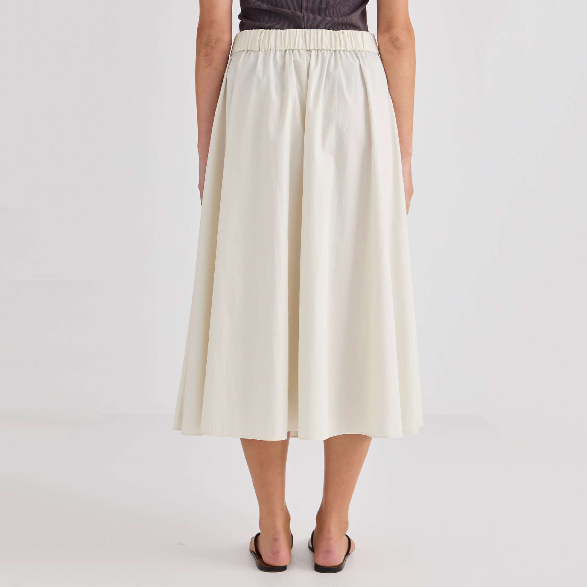 Laing Ellis Pleated Skirt - Cream, back view showcasing the elasticated waistband and flowy pleats.