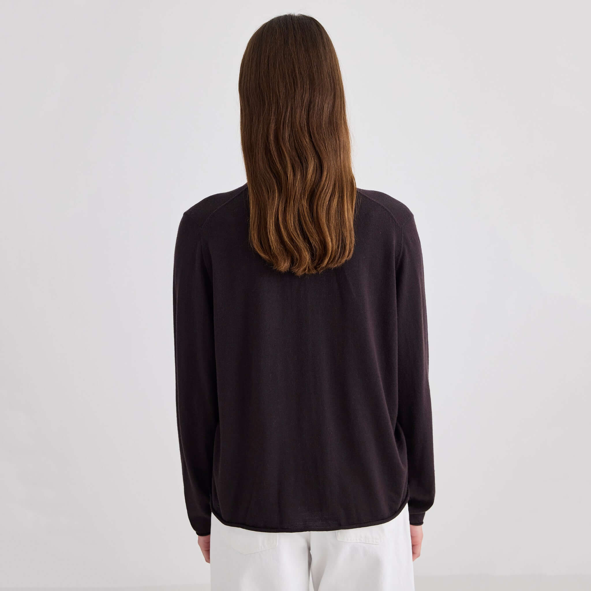 Woman wearing the Laing Liv V-Neck Merino Cardigan - Chocolate, viewed from the back.