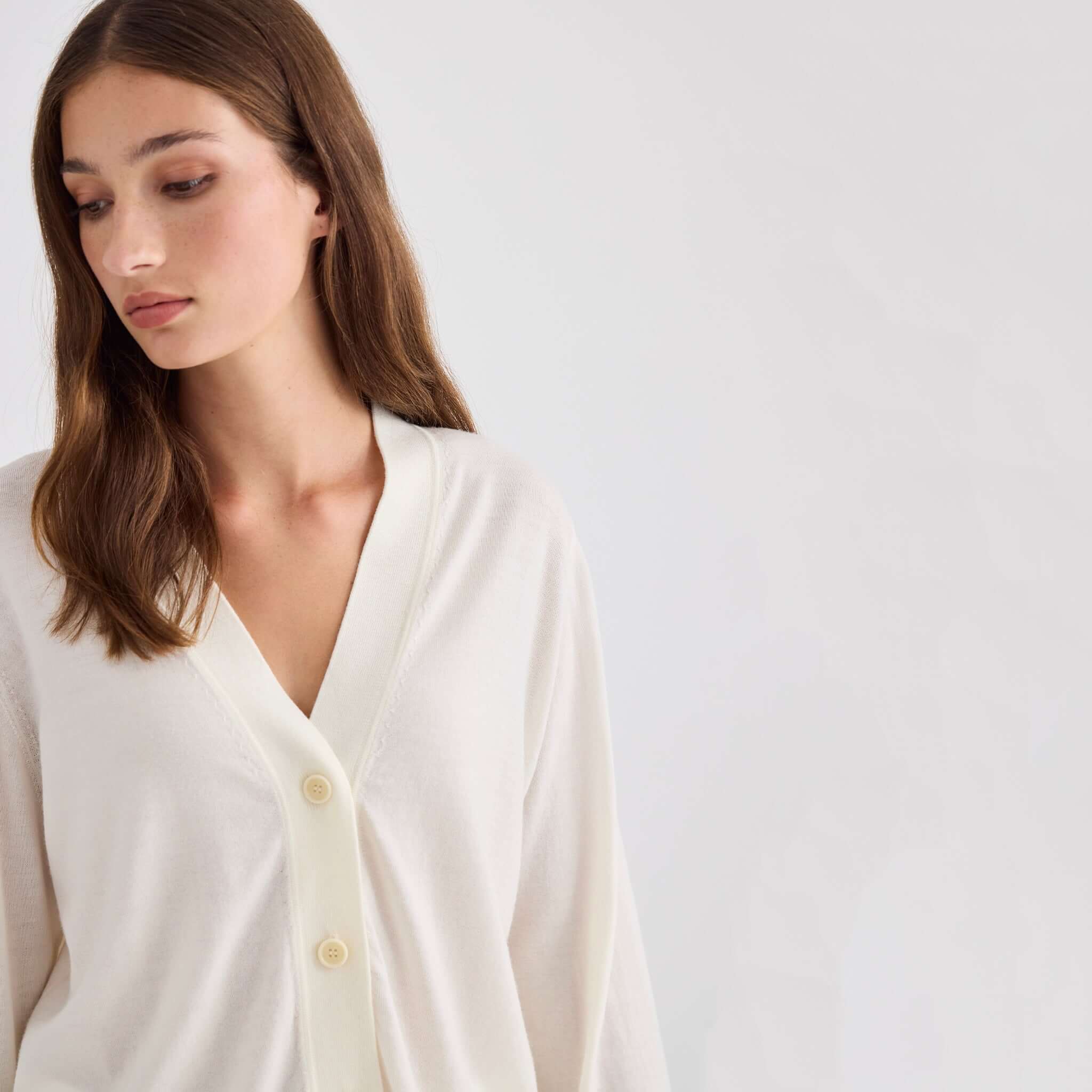Laing Liv V-Neck Merino Cardigan - Cream worn by model, showcasing relaxed fit and soft fabric in neutral tone.