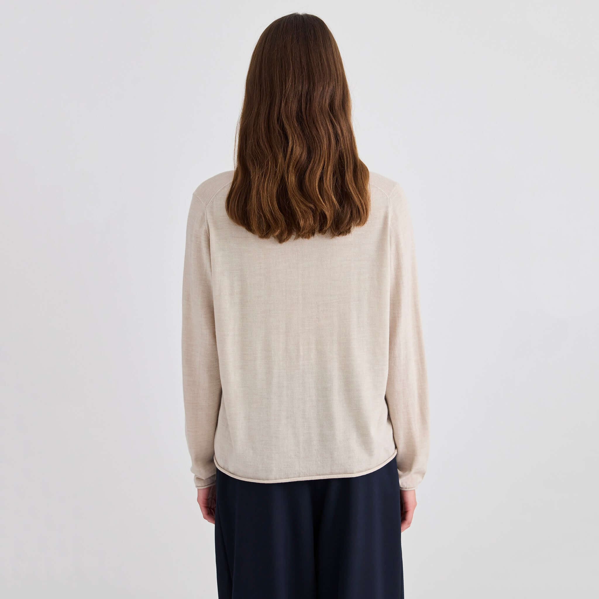 Back view of the Laing Liv V-Neck Merino Cardigan - Sand, showcasing its relaxed fit and soft fabric.