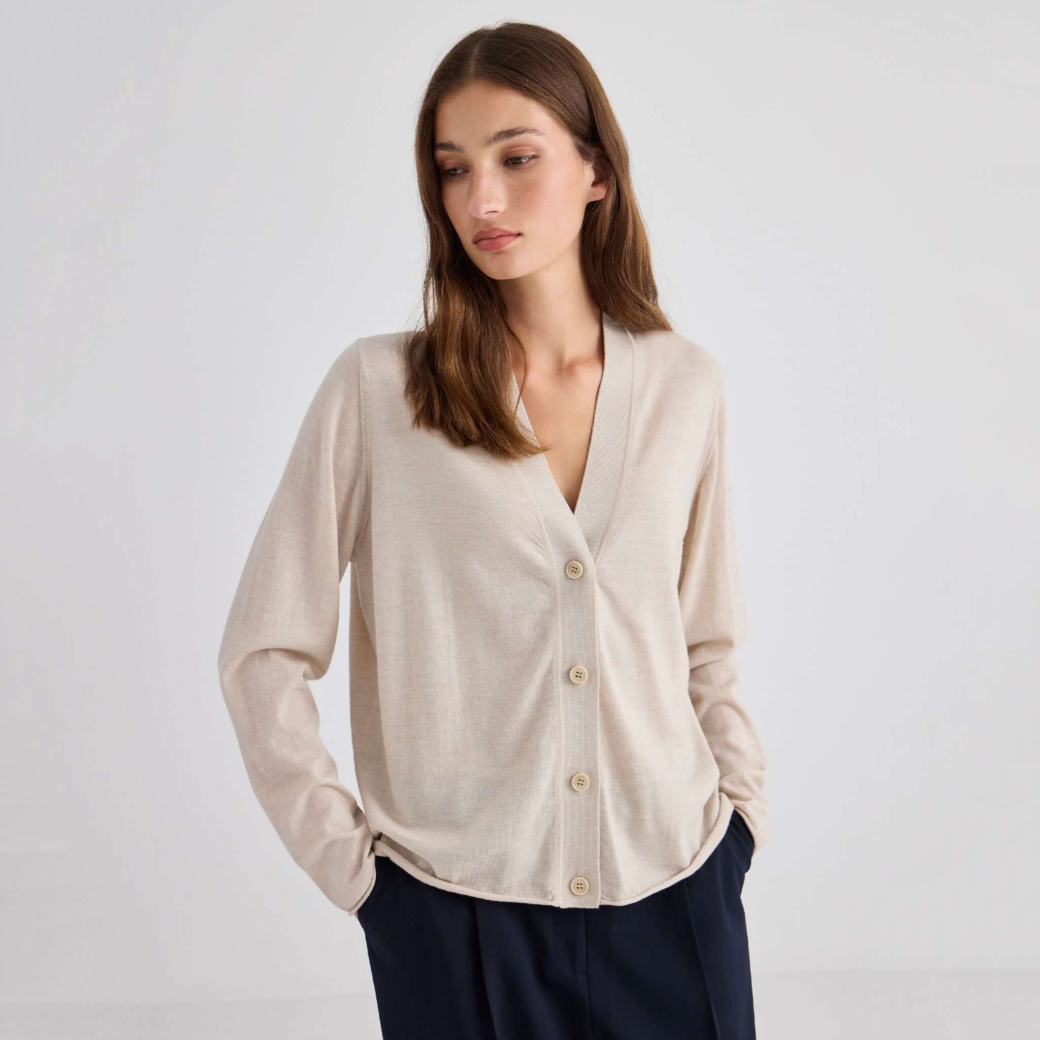 Laing Liv V-Neck Merino Cardigan - Sand displayed on a model, featuring a relaxed fit and elegant V-neck design.