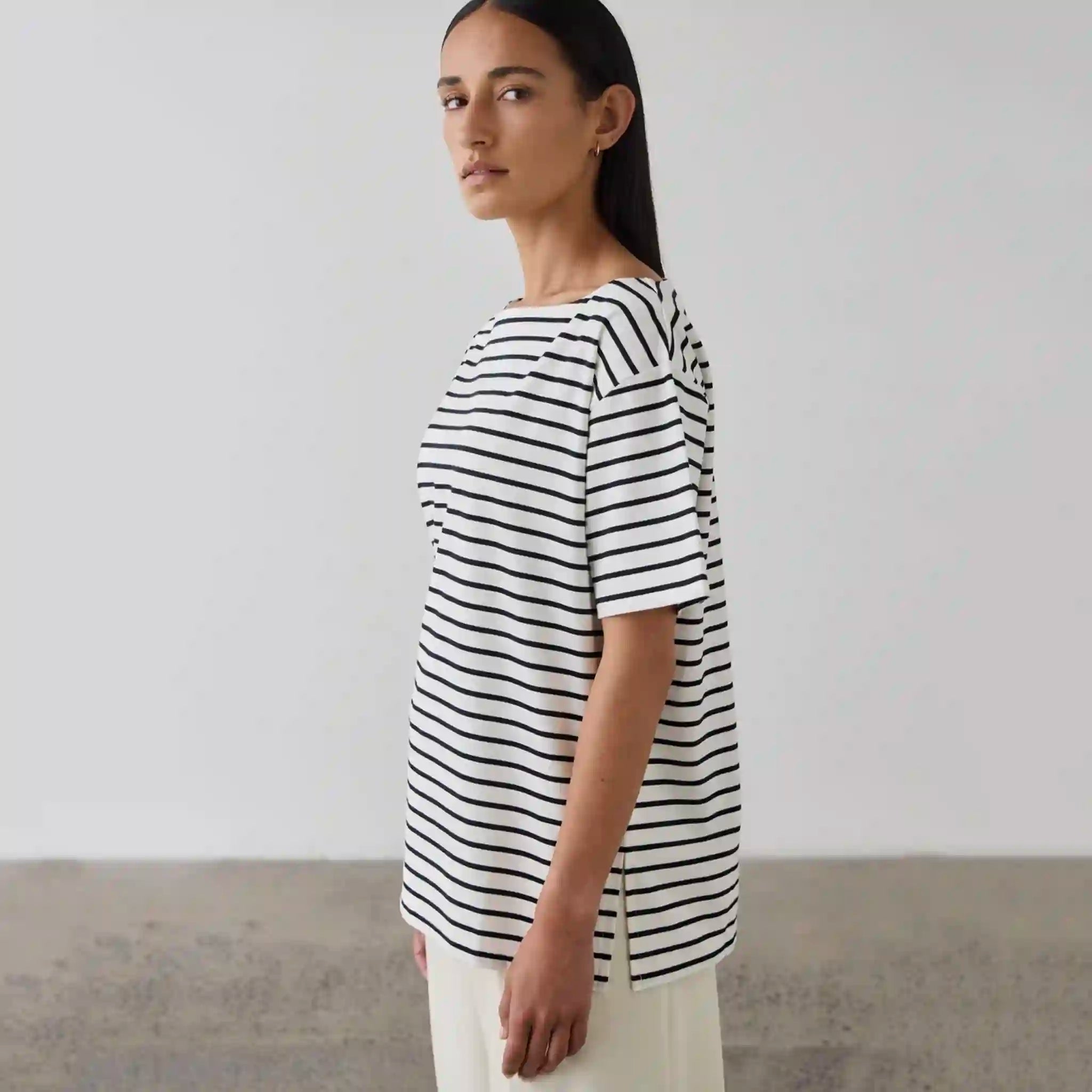 Woman wearing a black and white striped shirt against a plain background