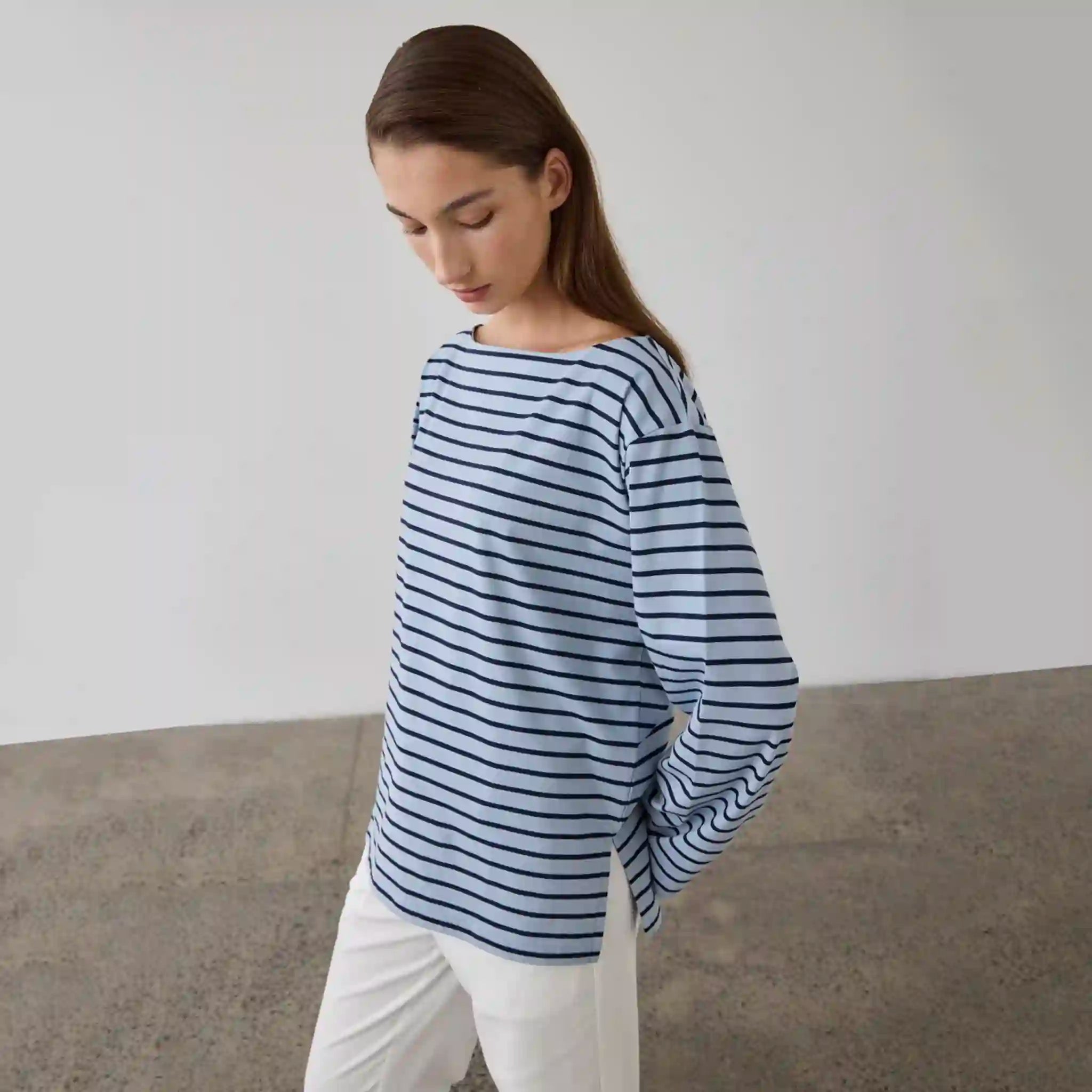 Woman wearing a blue and white striped shirt against a plain background