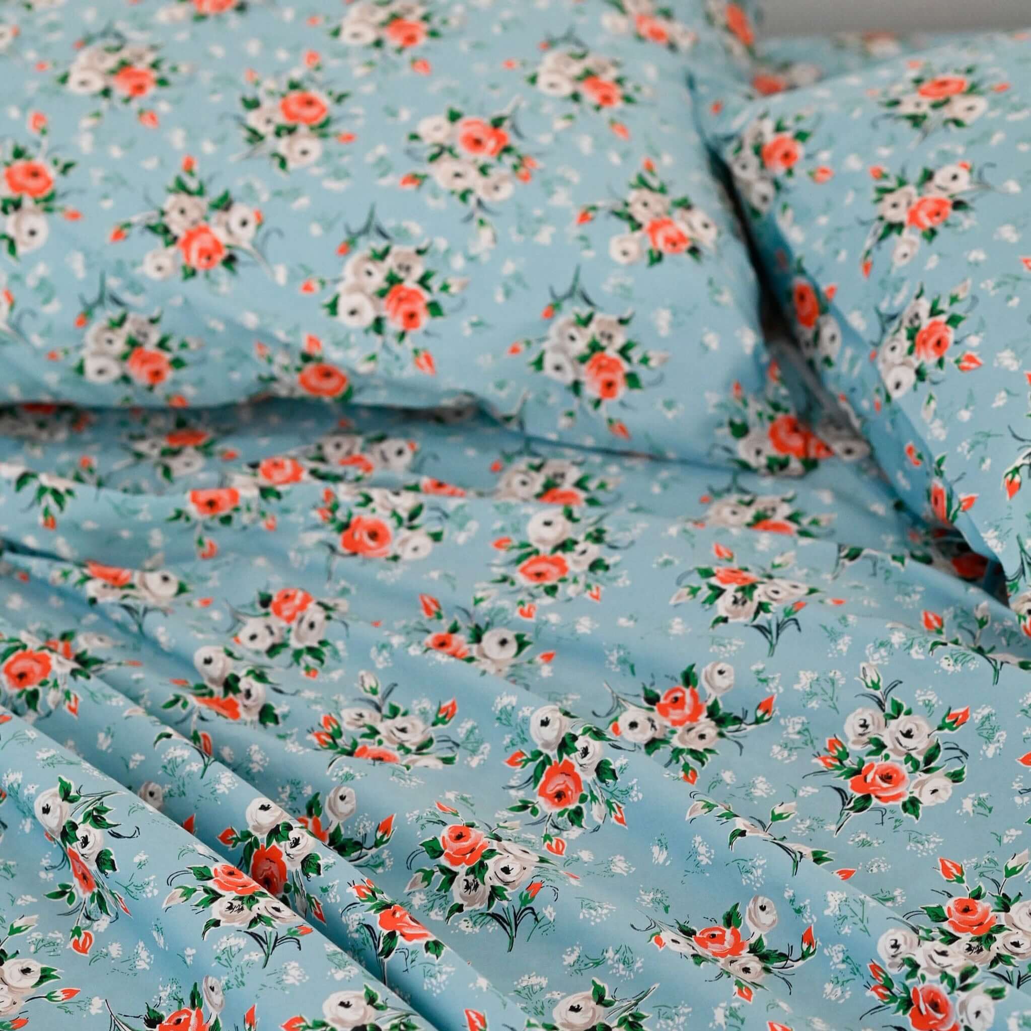 Alt Tag: Lazybones Organic Cotton Bedlinen Set - Rosebank sky blue bedding with coral, grey & white rose print organic cotton sheets