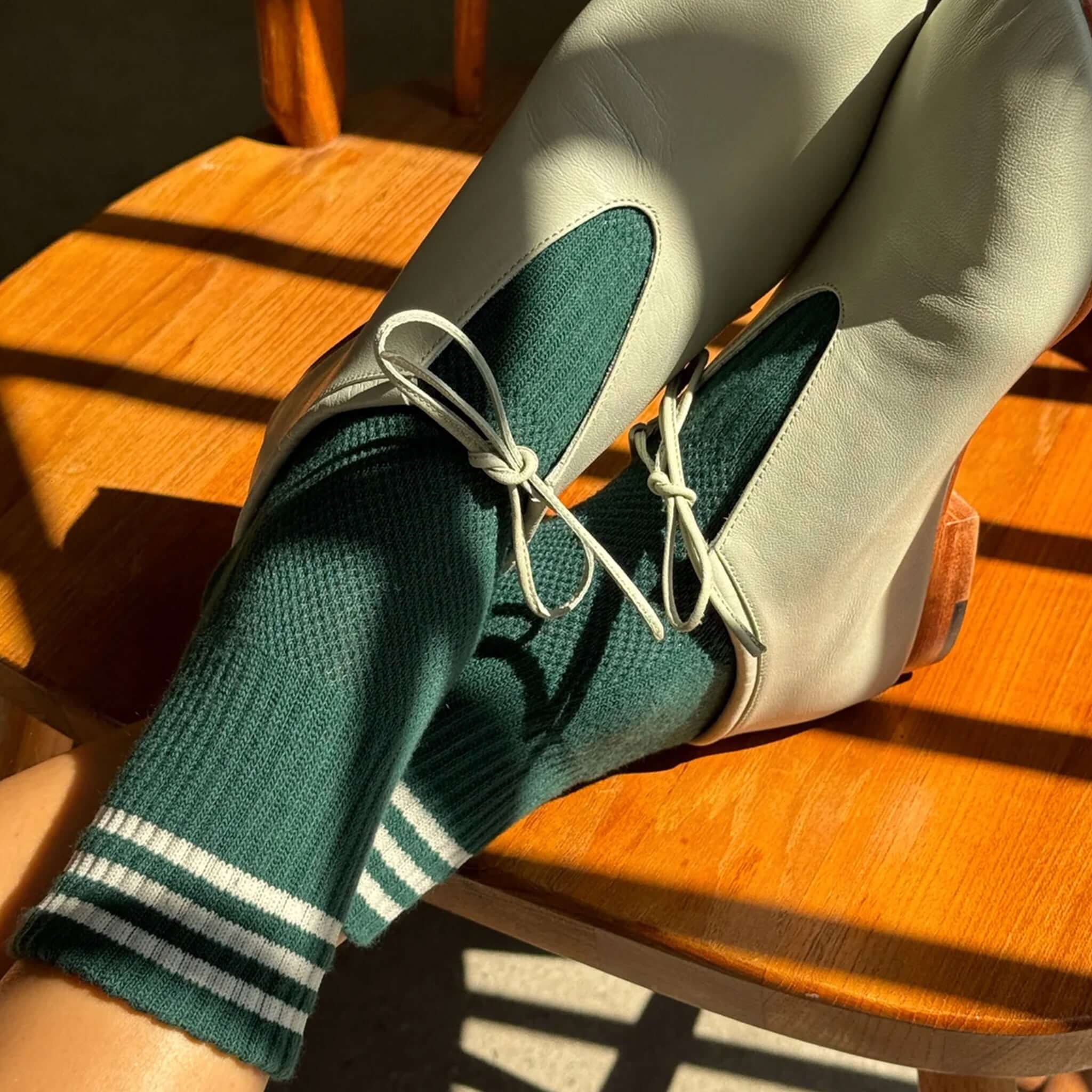 Le Bon Shoppe Girlfriend Socks - Hunter Green styled with fashionable footwear on a wooden chair.