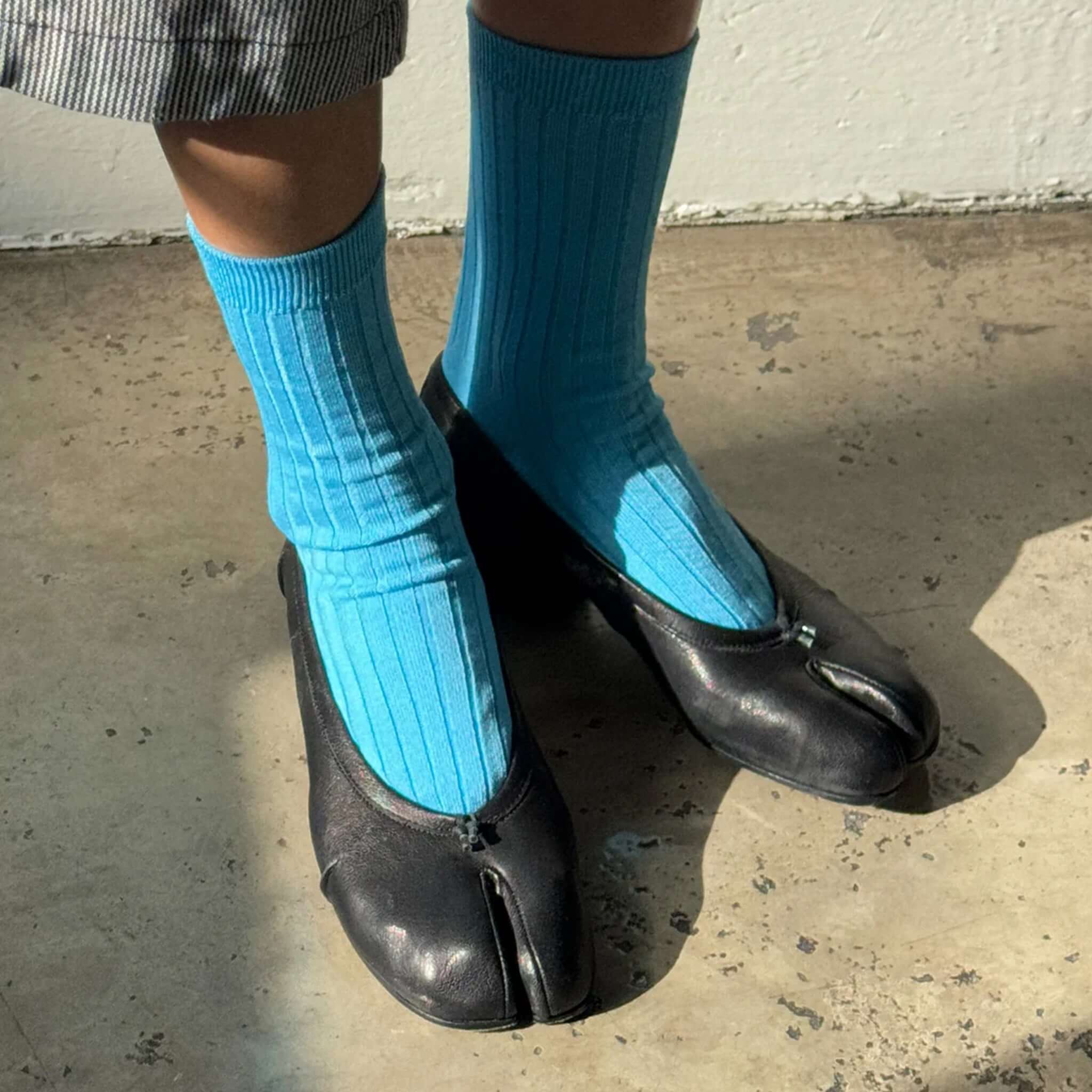 Le Bon Shoppe Her Cotton Socks - Blue Water worn with unique black shoes on a concrete floor.