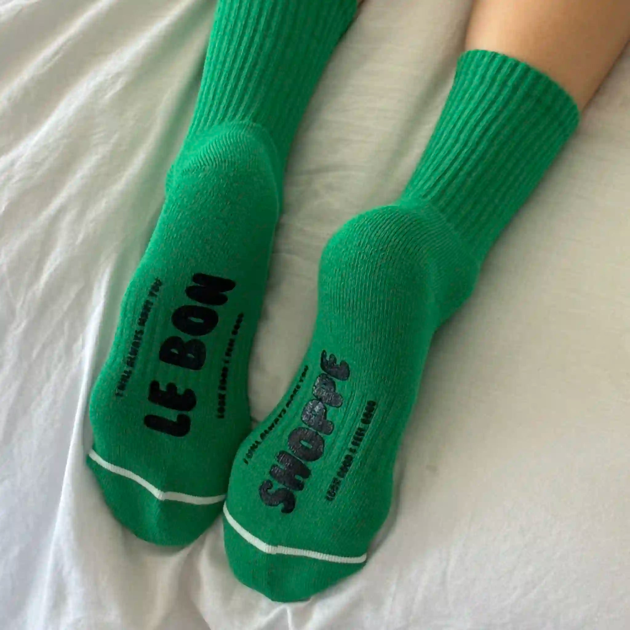 Green socks with text on a white surface