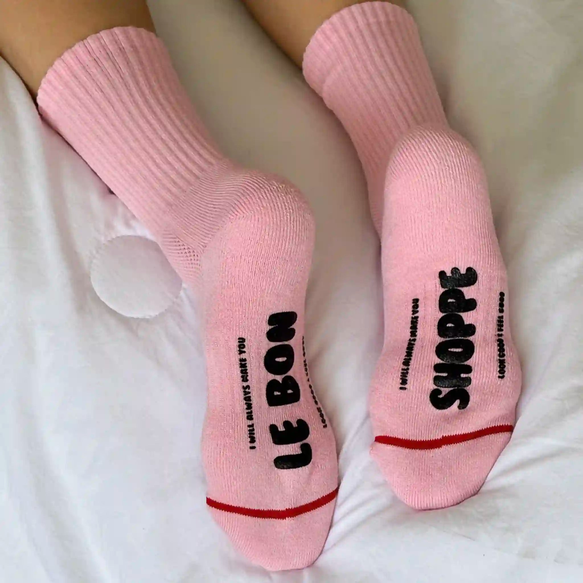 Pink socks with text on a white surface