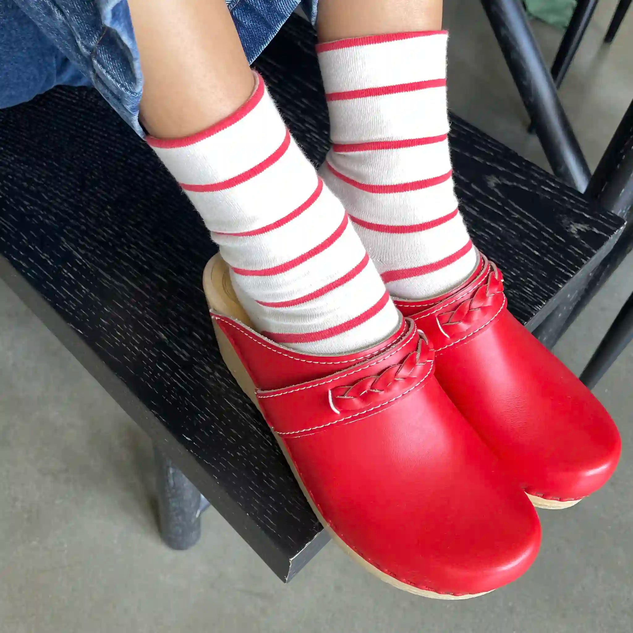 Red shoes and white socks with red stripes on a chair.