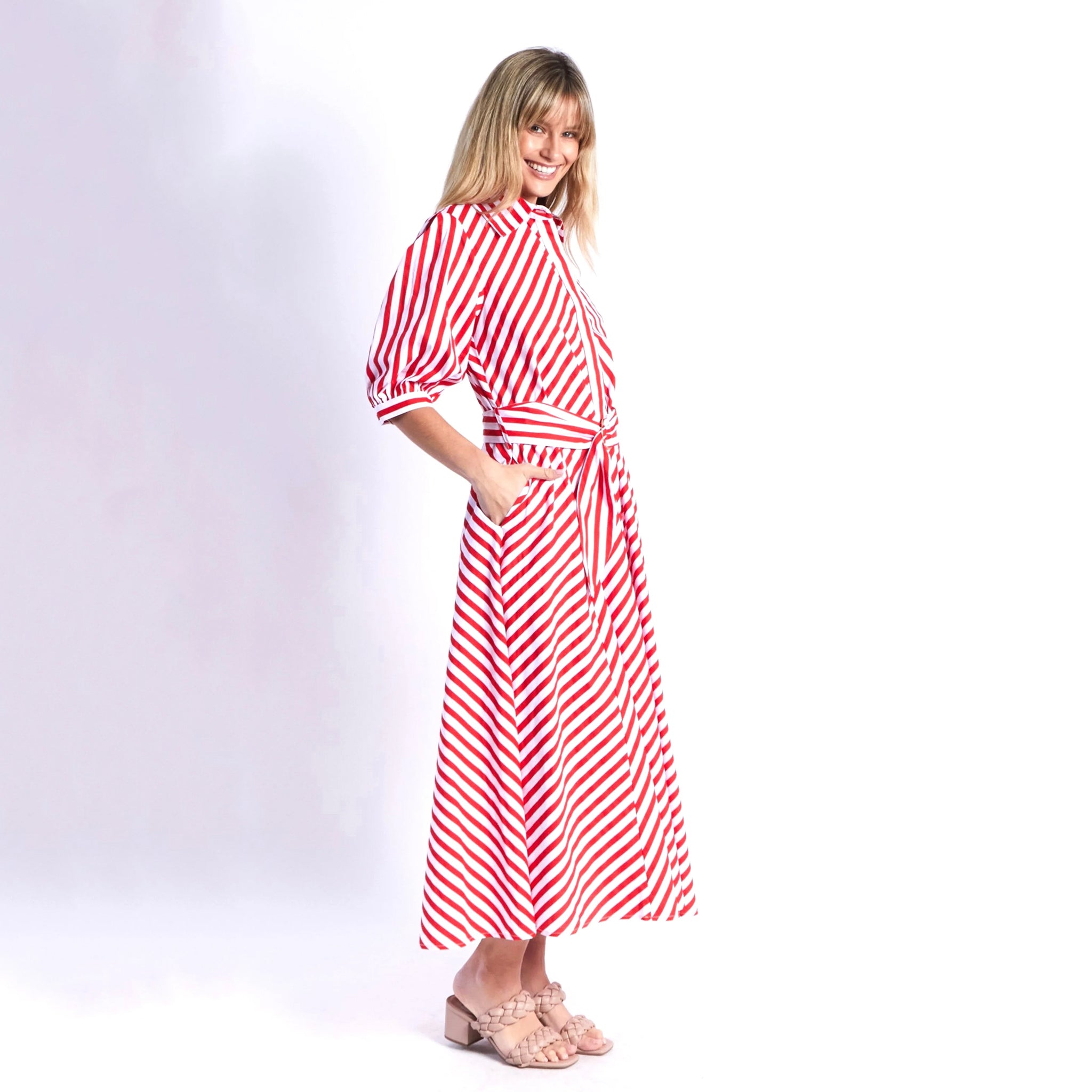 Woman wearing a red and white striped dress on a white background