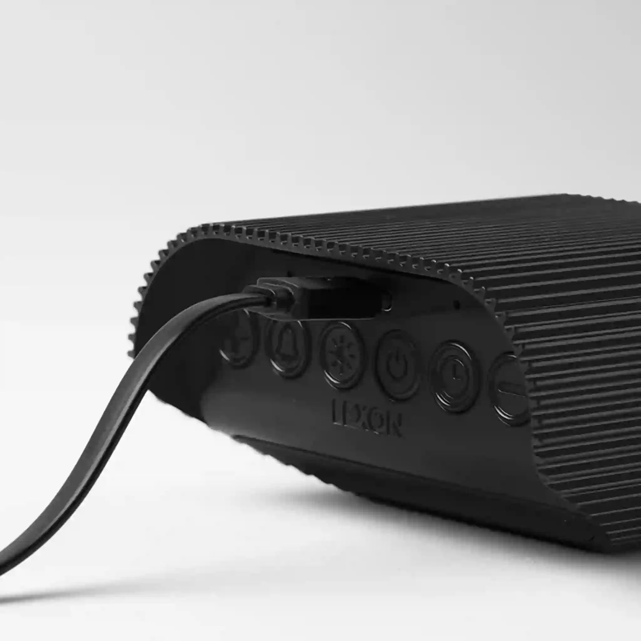 Black portable speaker with control buttons on a white background