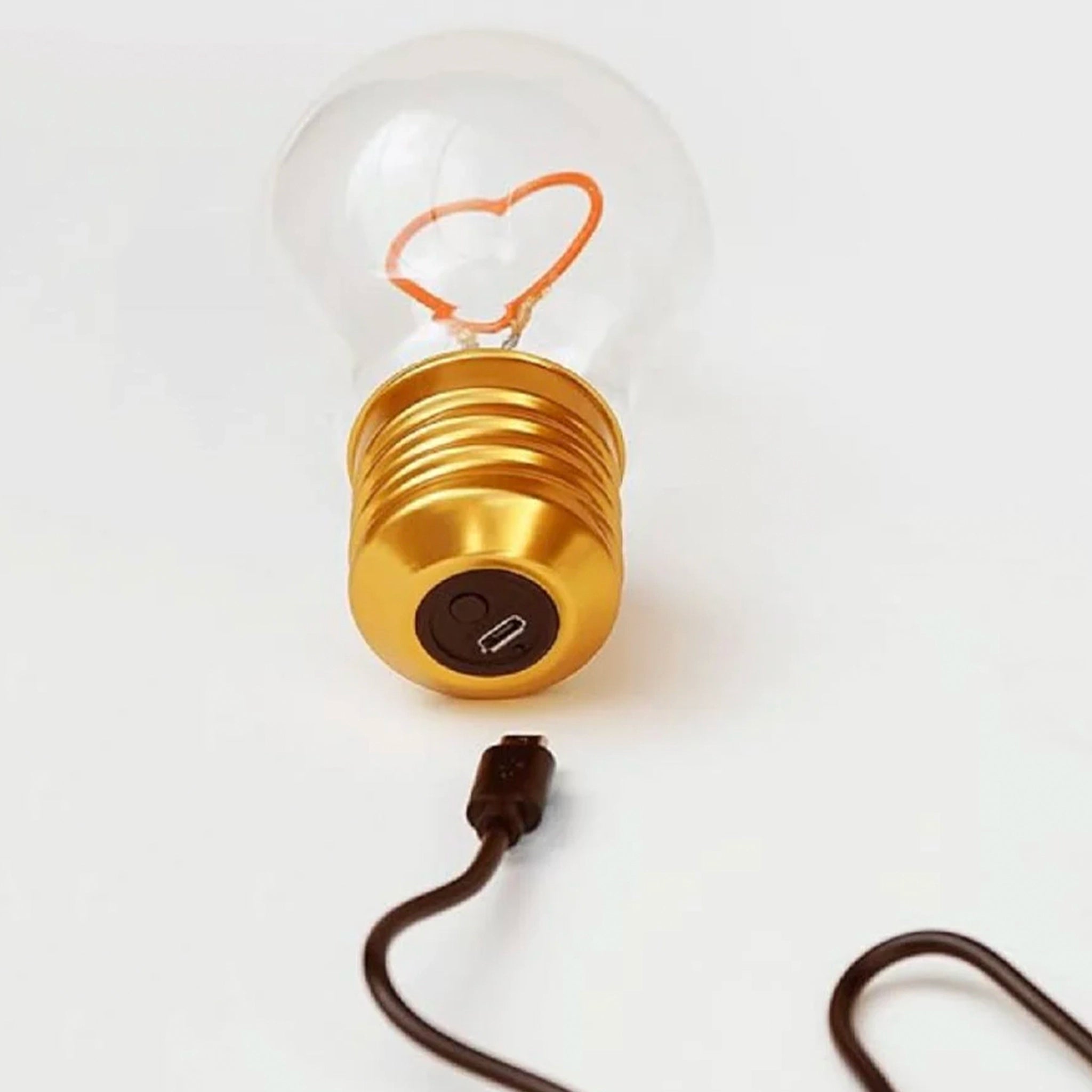 Gold light bulb-shaped lamp with a clear glass cover on a white background