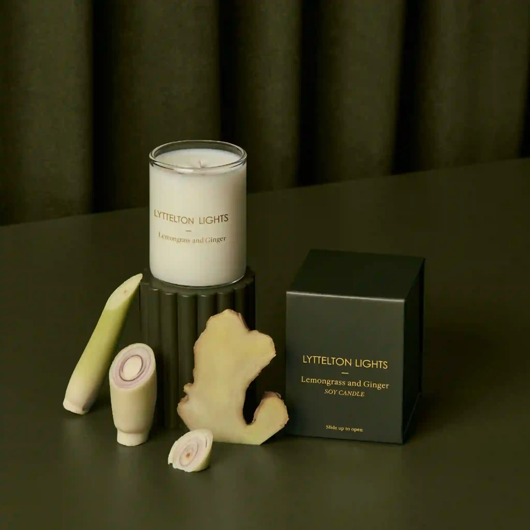 Lytelton Lights candle with lemongrass and ginger packaging on a dark surface