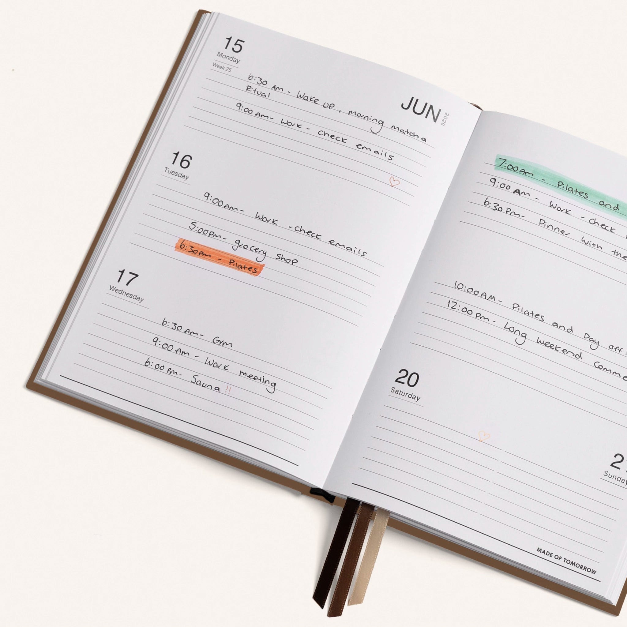 Open planner with daily schedule entries on a white background