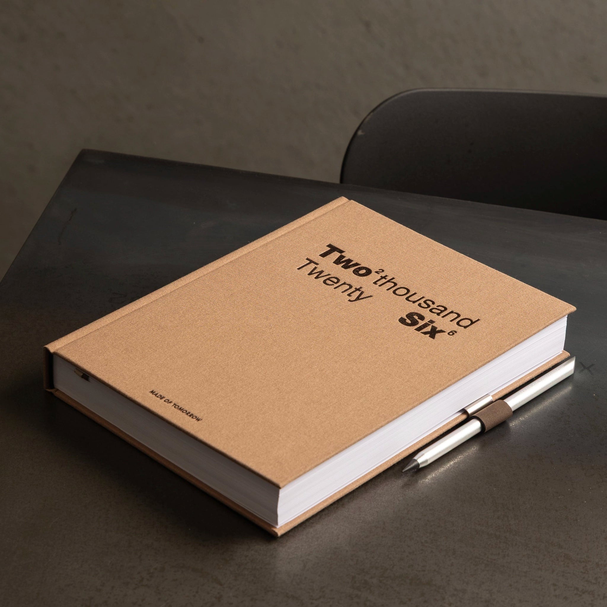 Brown notebook with 'Two Thousand Six' text on a dark surface