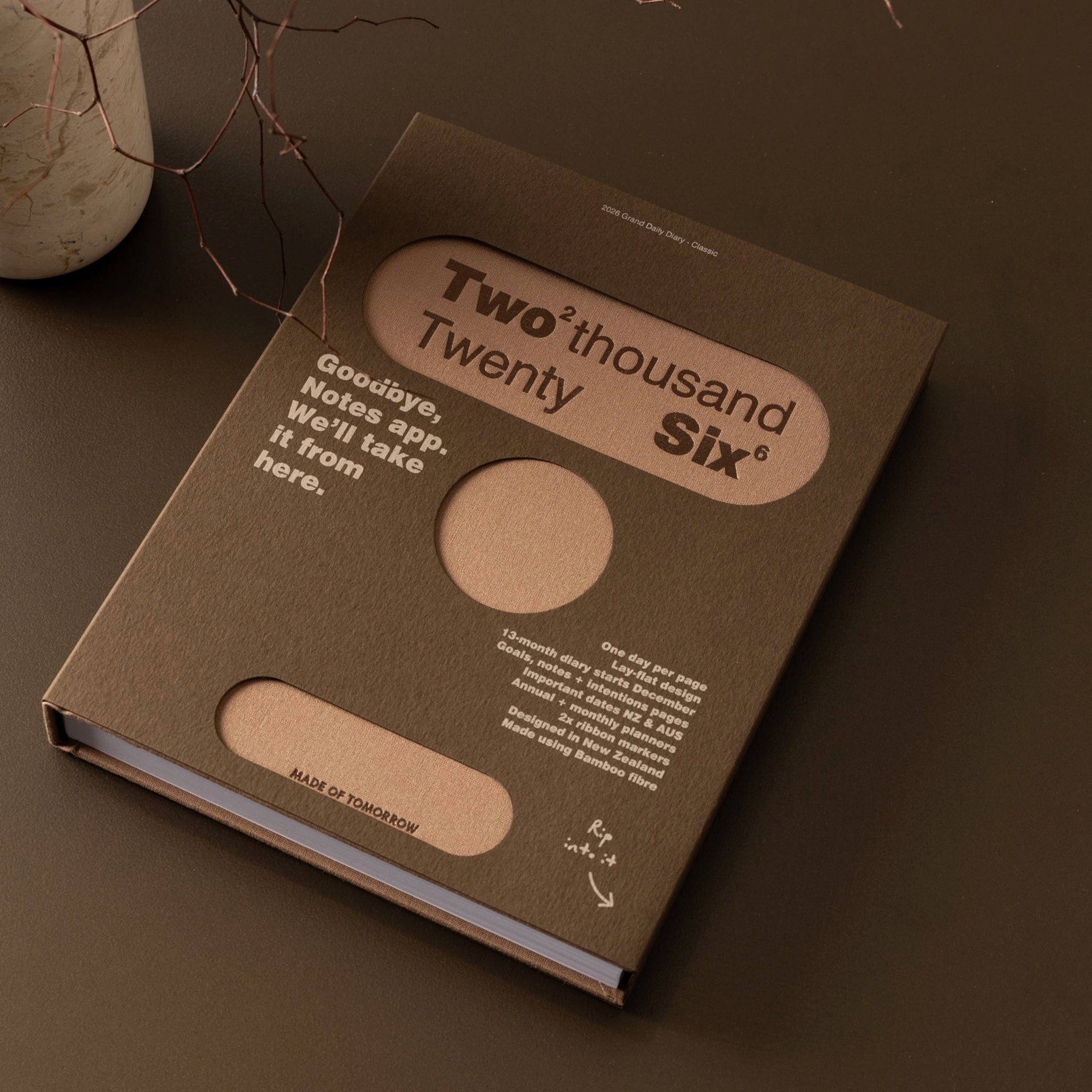 Brown notebook with 'Two Thousand Twenty Six' design on a dark surface