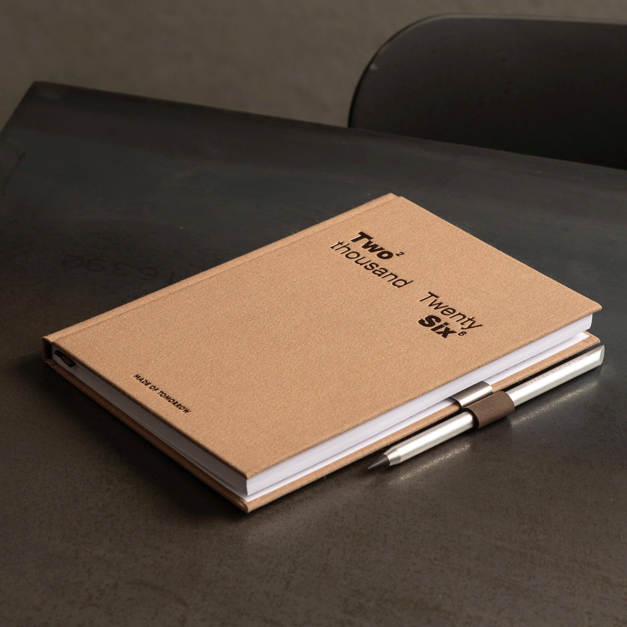 Kraft notebook with a pen on a dark surface