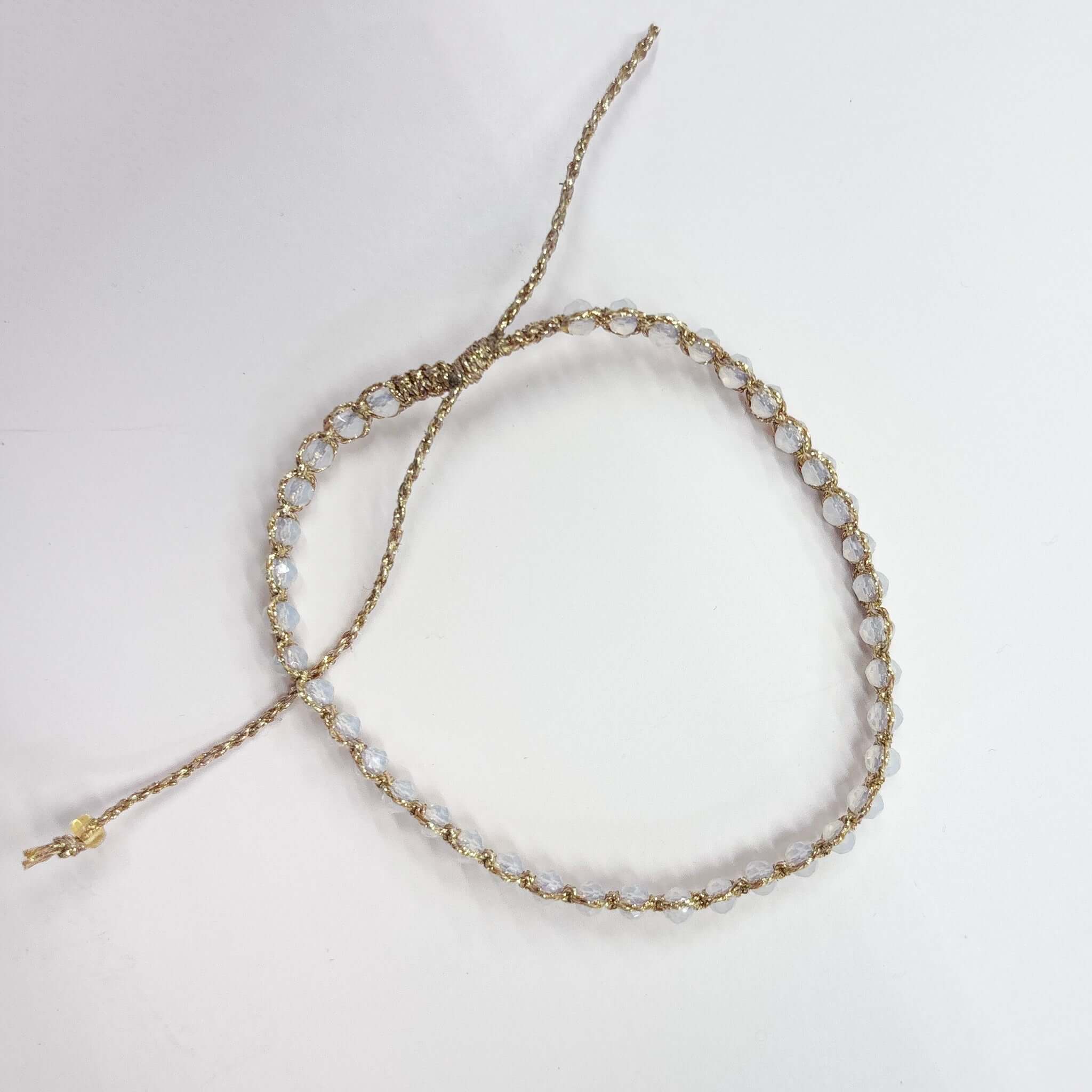 Margaret Adeline Bracelet featuring delicate faceted crystals on a gold thread cord with adjustable closure.