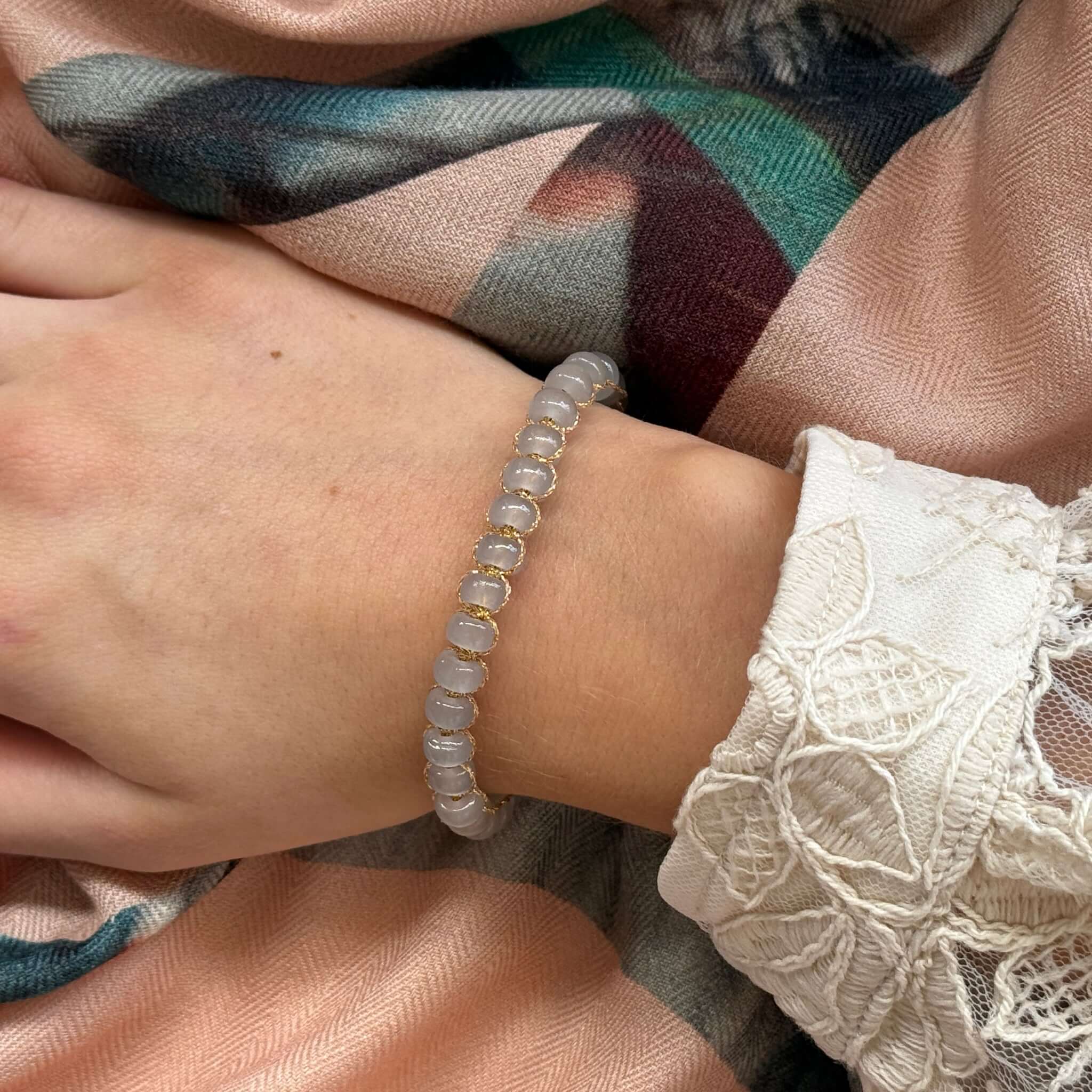 Margaret Edna Bracelet featuring chunky beads on a fine gold metallic cord, adjustable sliding closure.
