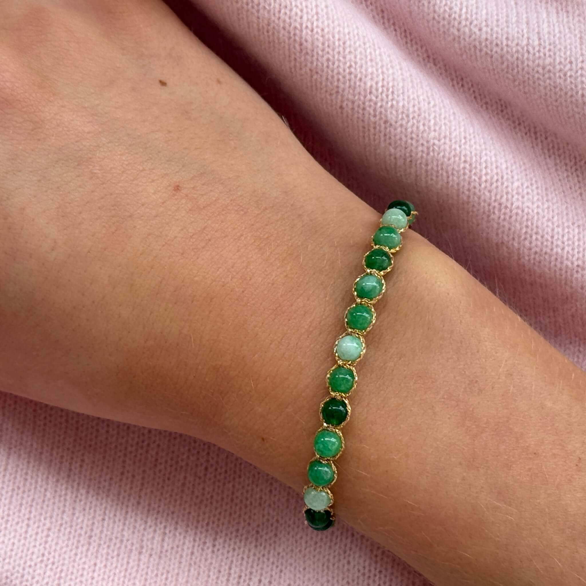 Margaret Ellen Bracelet featuring smooth round stone beads in green tones on wrist.