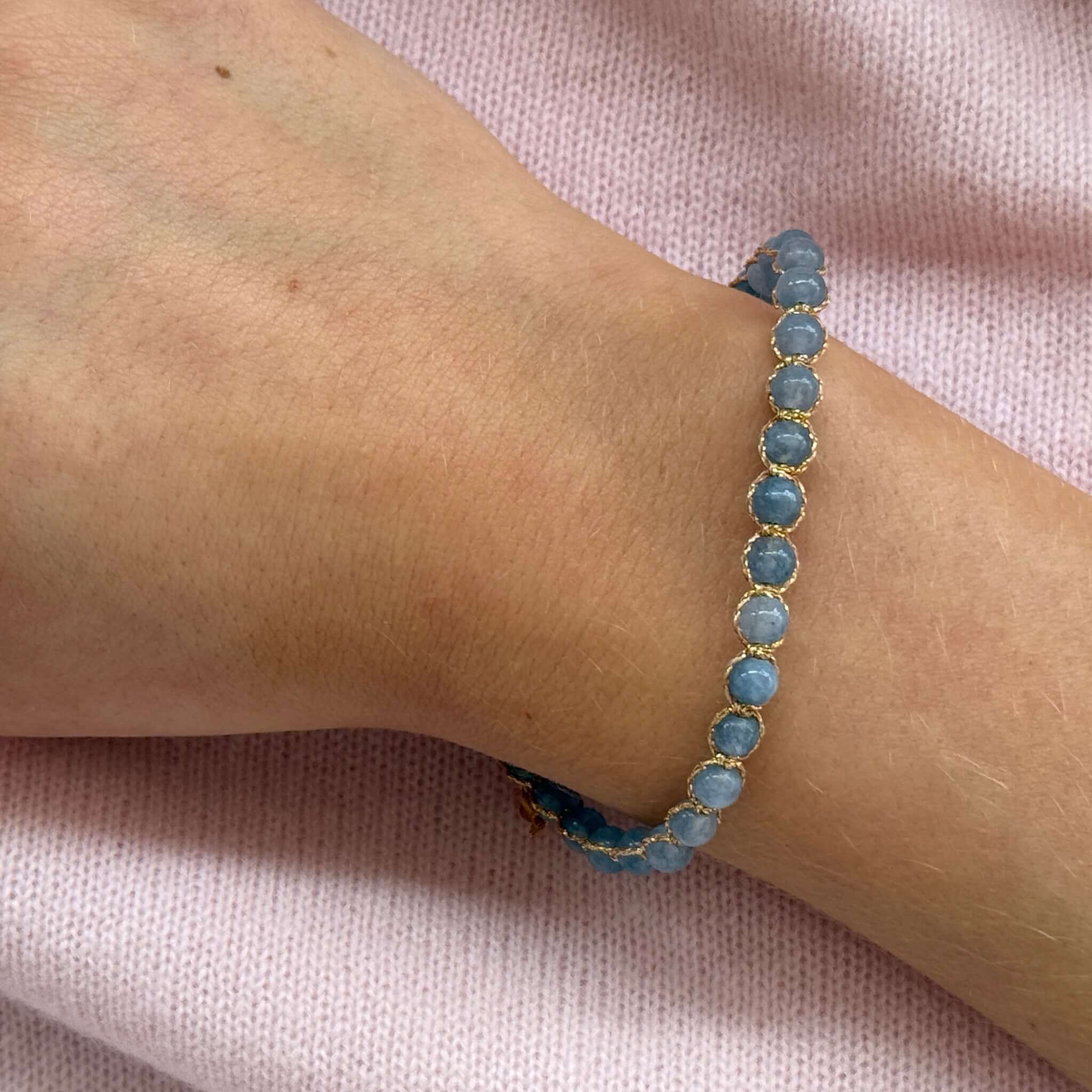Margaret Ellen Bracelet featuring smooth, round blue stone beads in delicate gold thread on wrist.