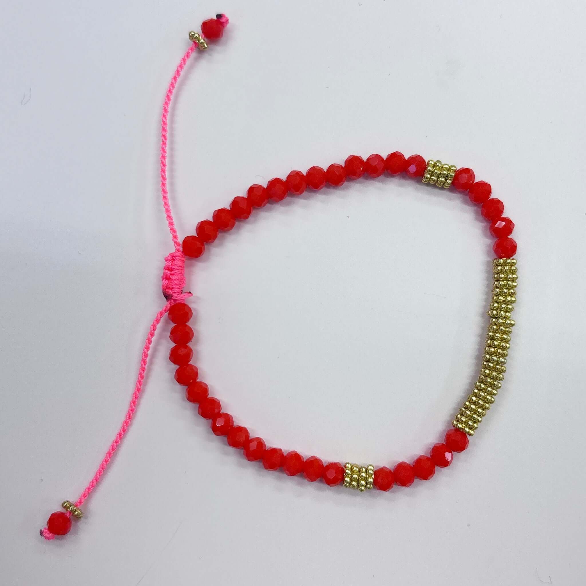 Bright red crystal bead bracelet with gold accents and adjustable sliding cord closure.