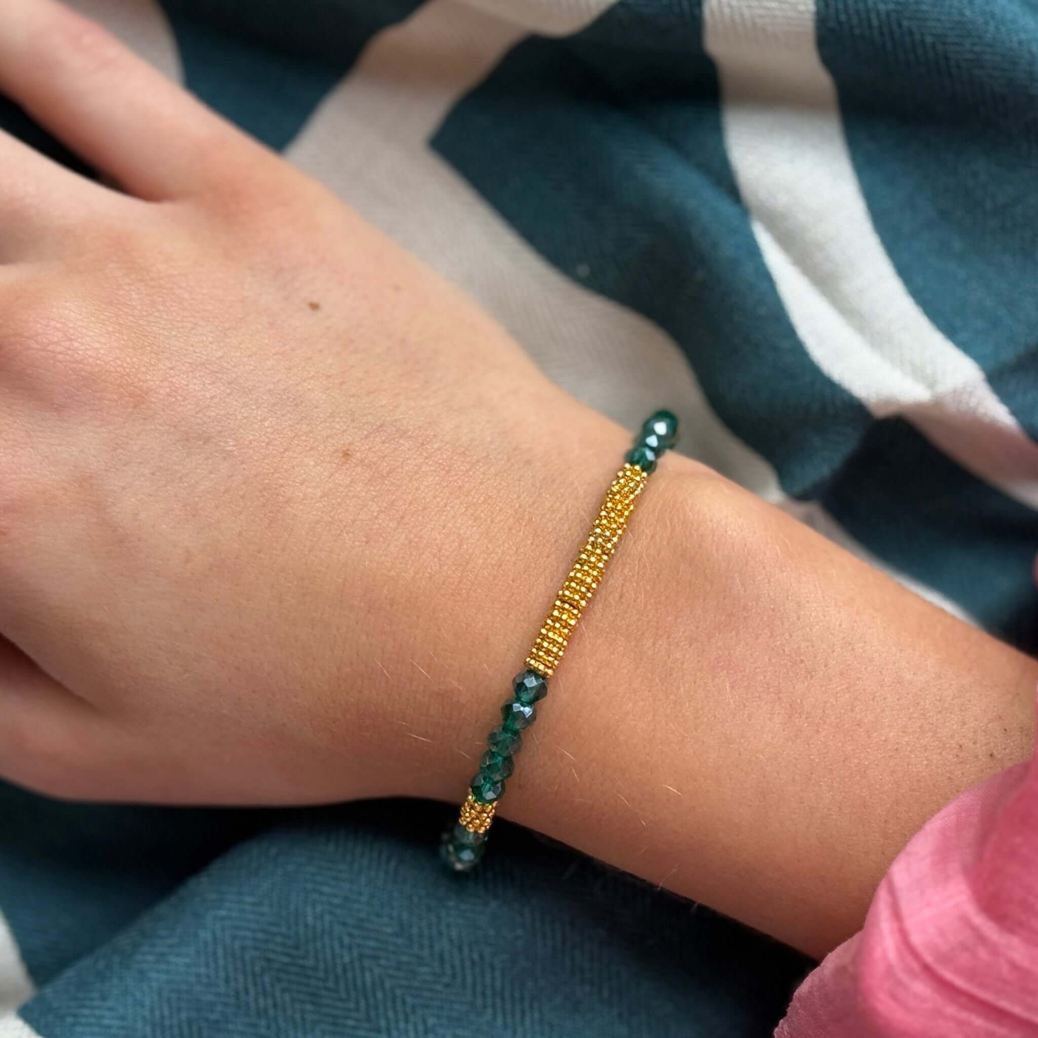 Close-up of the Margaret Lola Bracelet with crystal beads and woven gold bead bar on a hand.