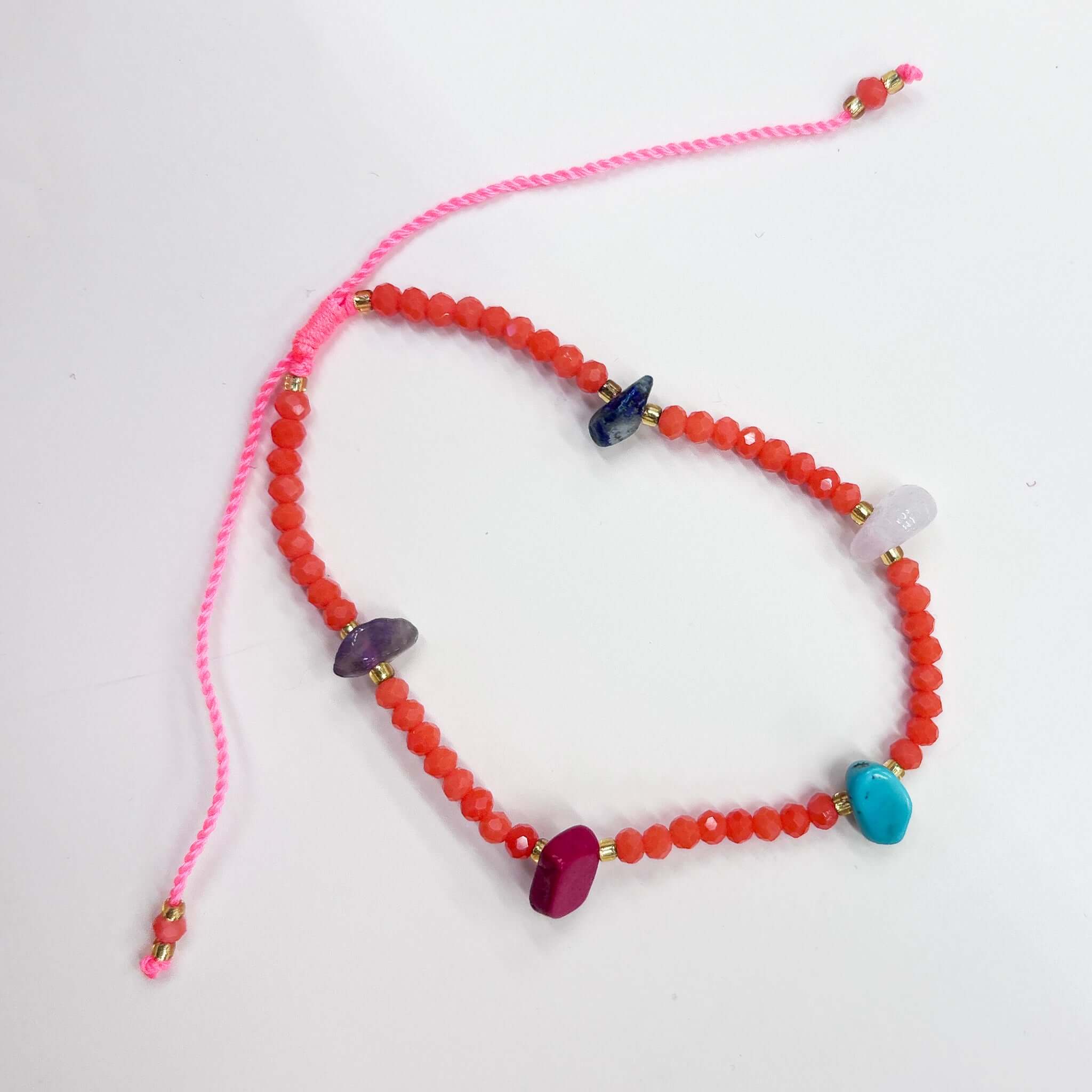 Margaret Lucille Bracelet featuring vibrant red crystal beads and colorful chunky natural stones.