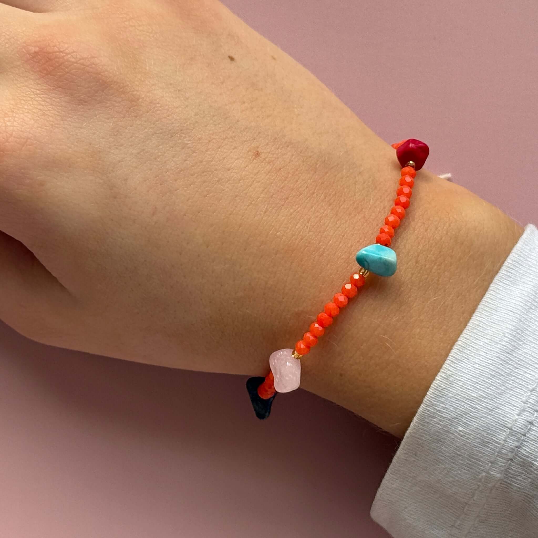 Margaret Lucille Bracelet featuring colorful crystal beads and natural stone accents on a hand.