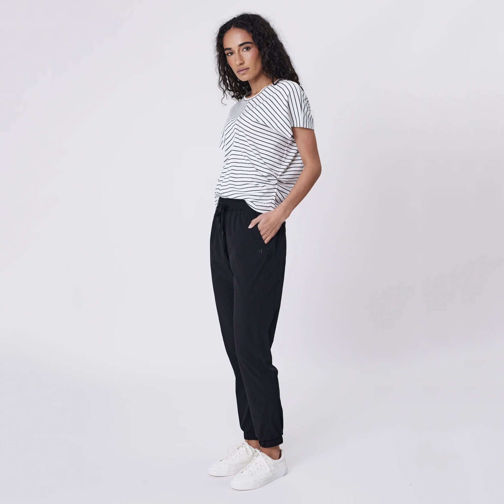 Marlow Travel Pants - Black worn by model, tapered leg featherlight stretch travel trousers with drawstring waist and zip pockets