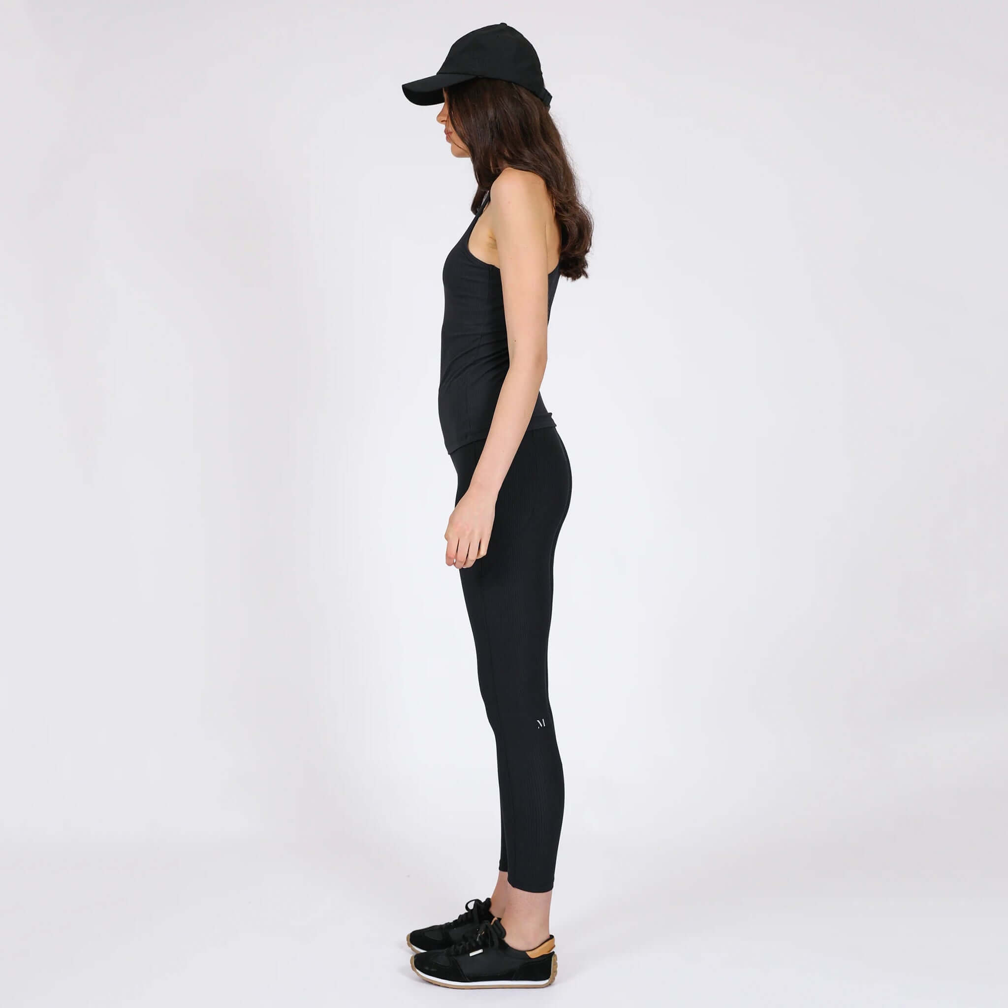 Marlow Contour Air Tank - Black showcased on a model wearing fitted black leggings and a cap.