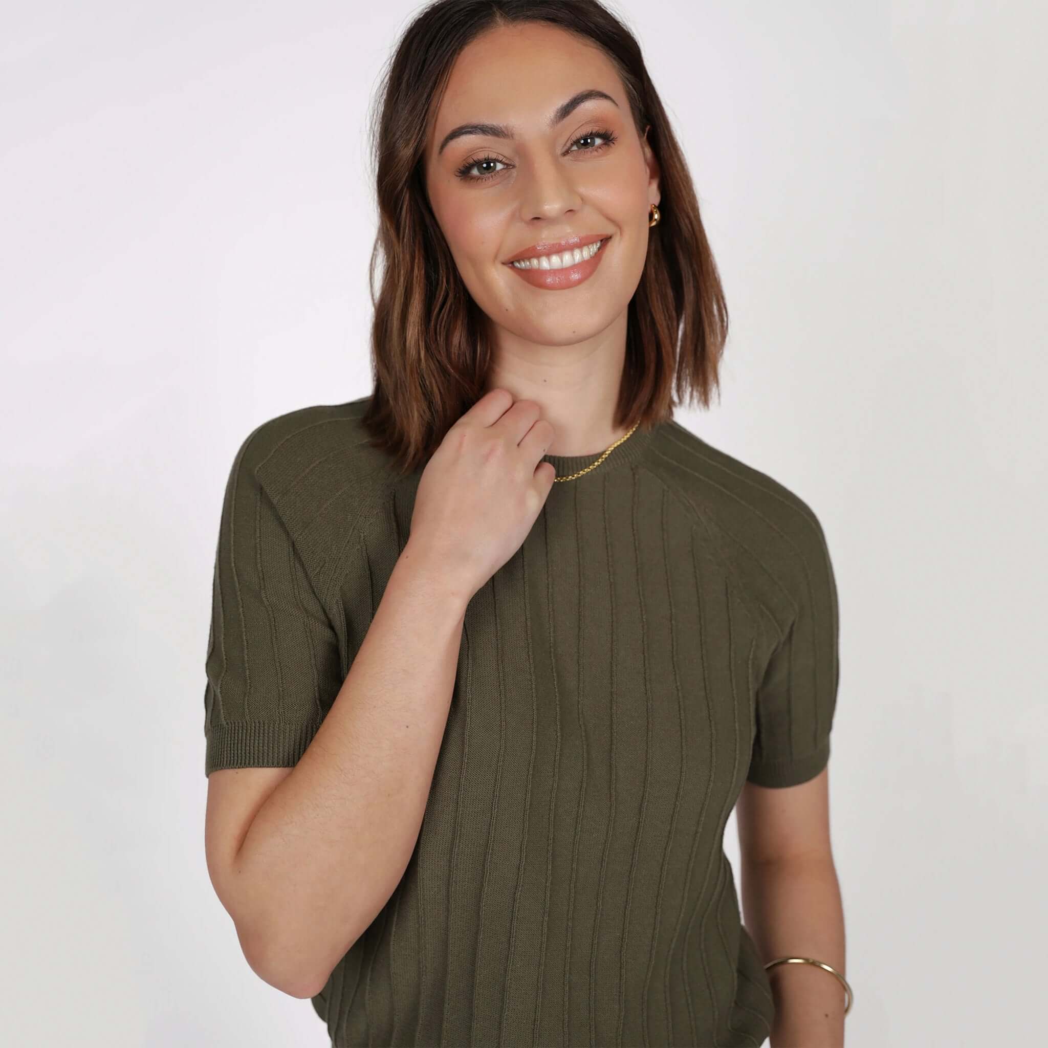 Marlow Soleil Knit Tee - Olive featuring a model smiling and wearing the olive-colored ribbed knit tee.