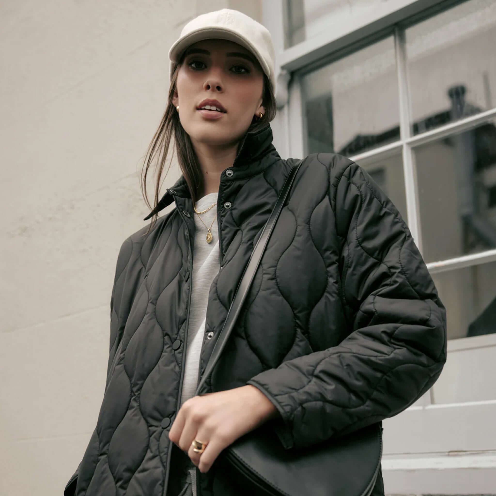 Marlow Toronto Quilted Jacket - Black worn by a model against a window wearing a cap.