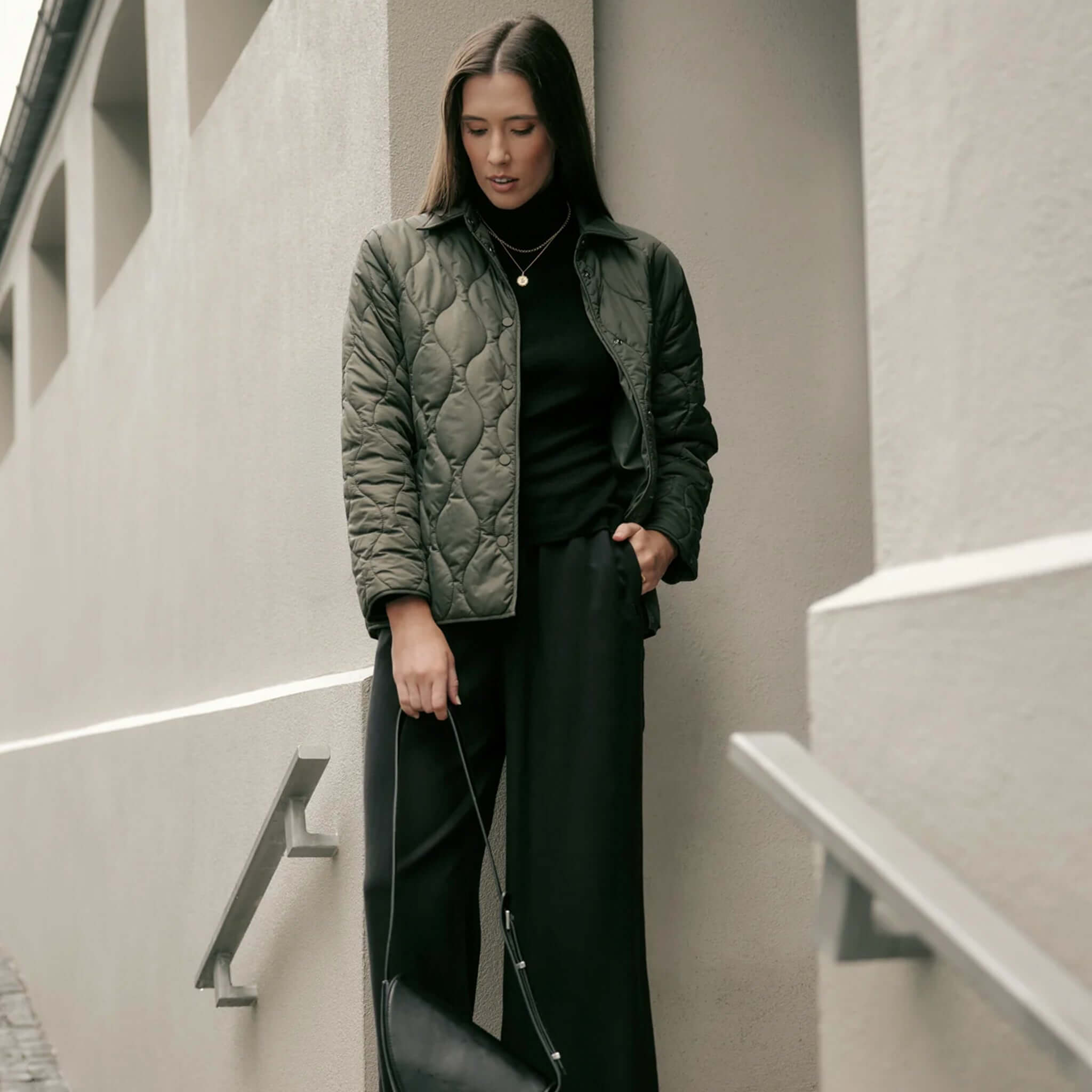 Marlow Toronto Quilted Jacket - Spruce worn by a woman in a modern urban setting.