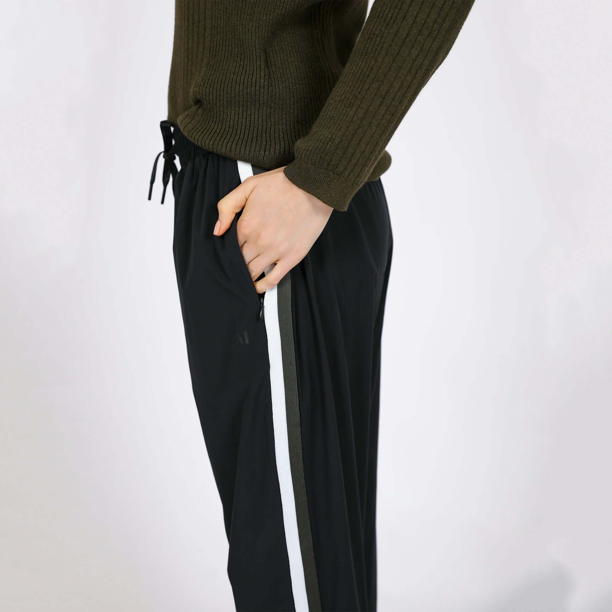 Alt Tag: Marlow Transit Pants - Black side view on model, featherlight stretch travel pants with drawstring waist and stripe detail